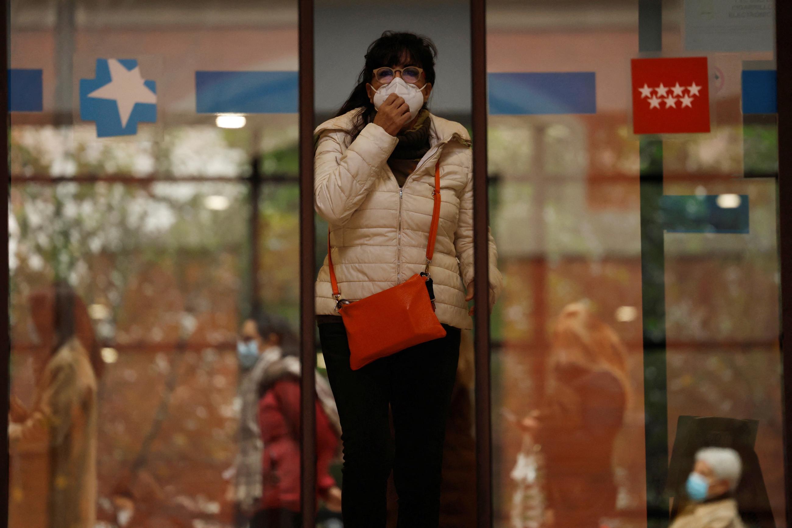 A woman wearing a protective face mask leaves a health center in Madrid, Spain, January 10, 2024.