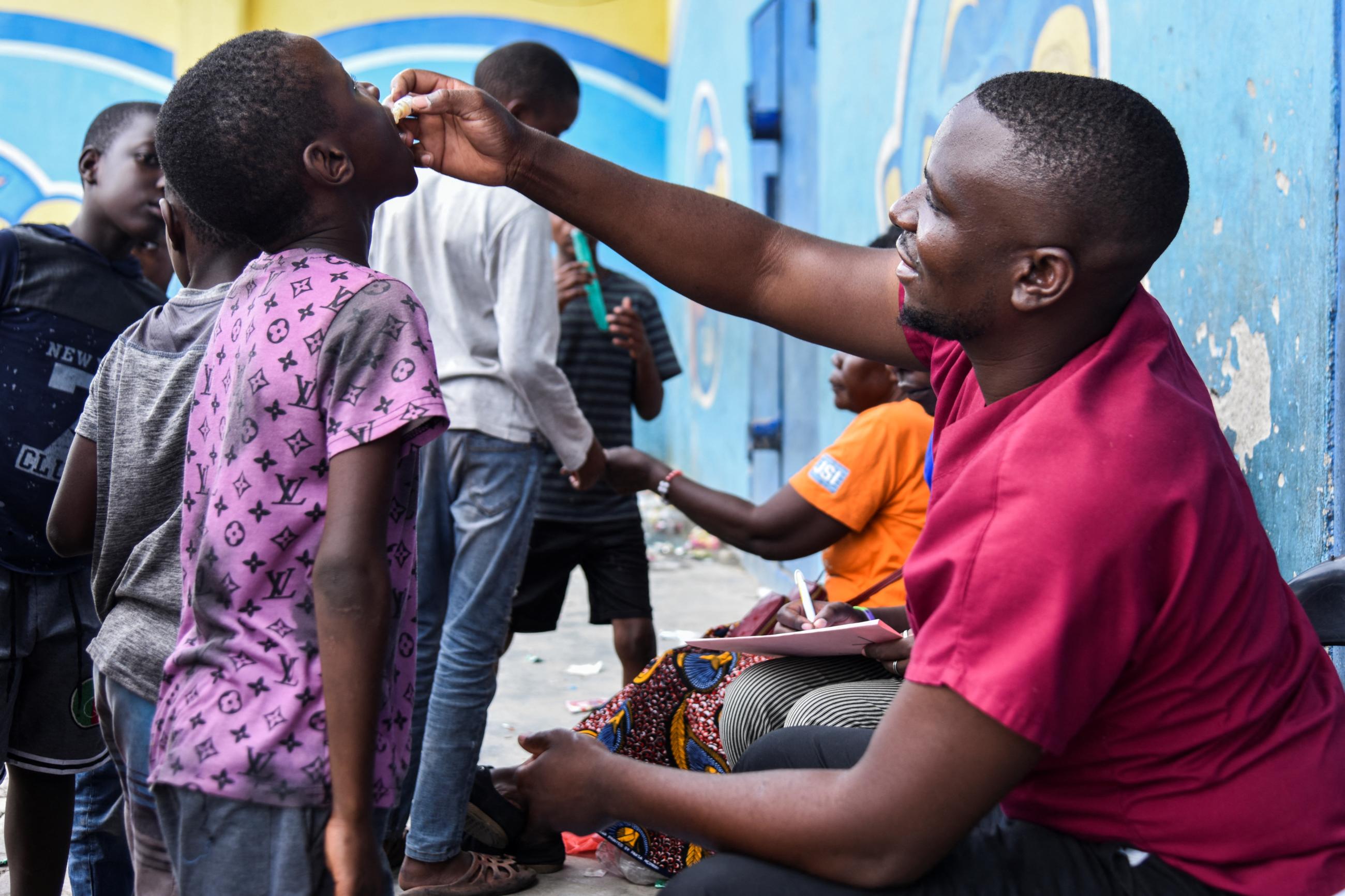 A man administers the cholera vaccine to a child at a temporary cholera treatment center.