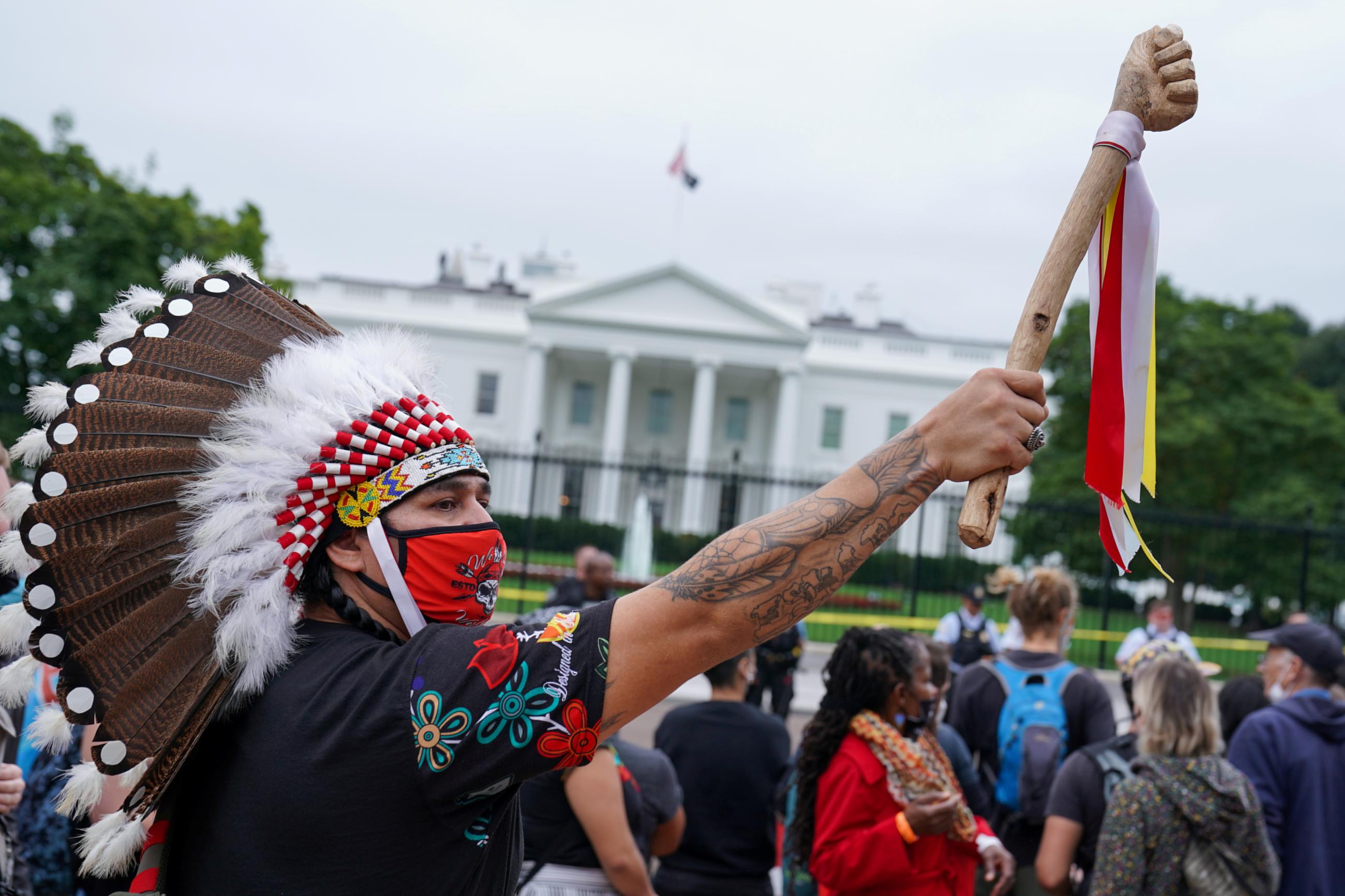 A demonstrator wears a traditional Native American headdress during an Indigenous Peoples' Day protest outside of the White House.