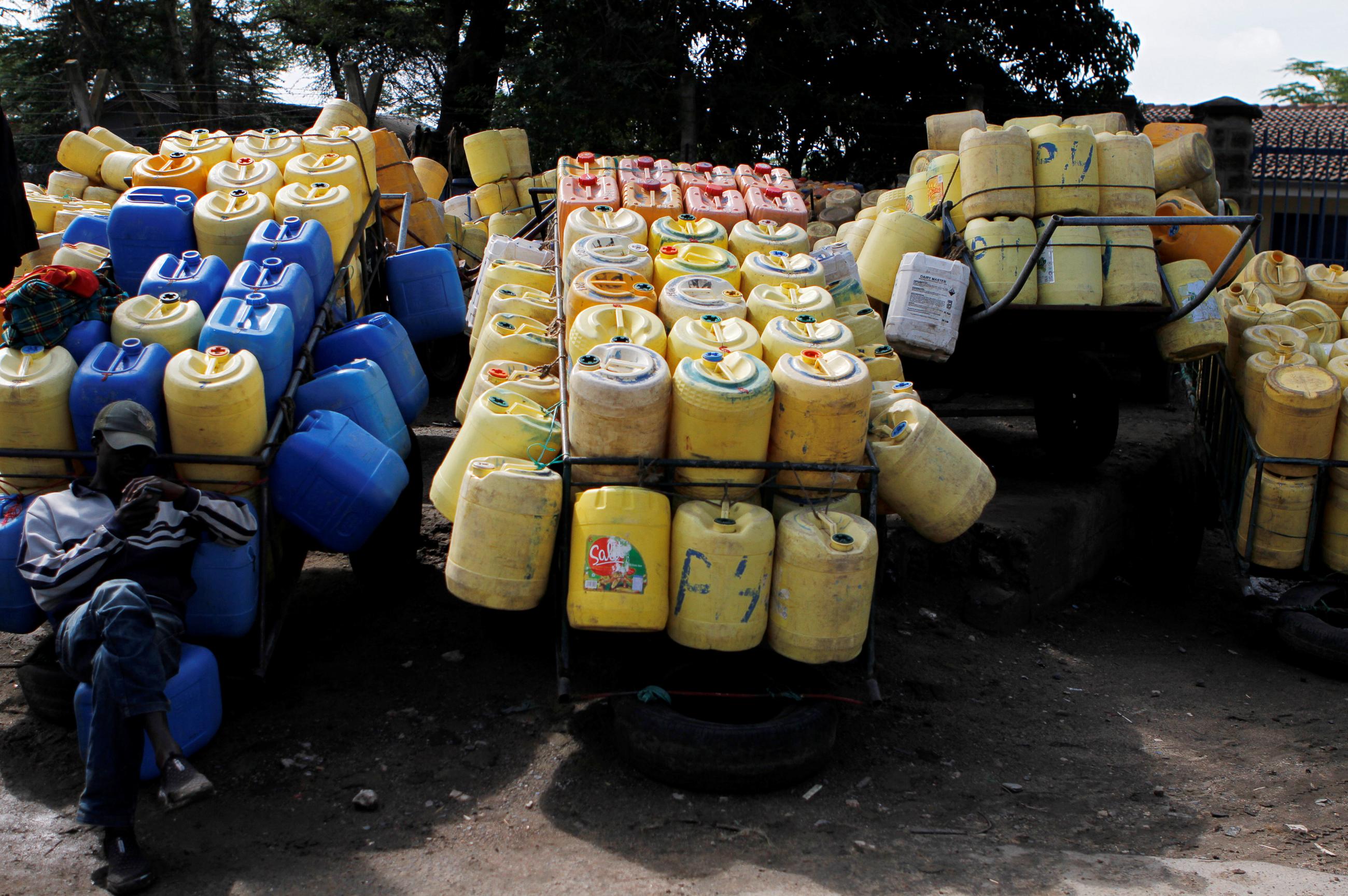 A vendor sits near his handcarts carrying empty jerrycans before distributing fresh water to his clients in Athi River, on the outskirts of Nairobi, Kenya, on April 19, 2018. 