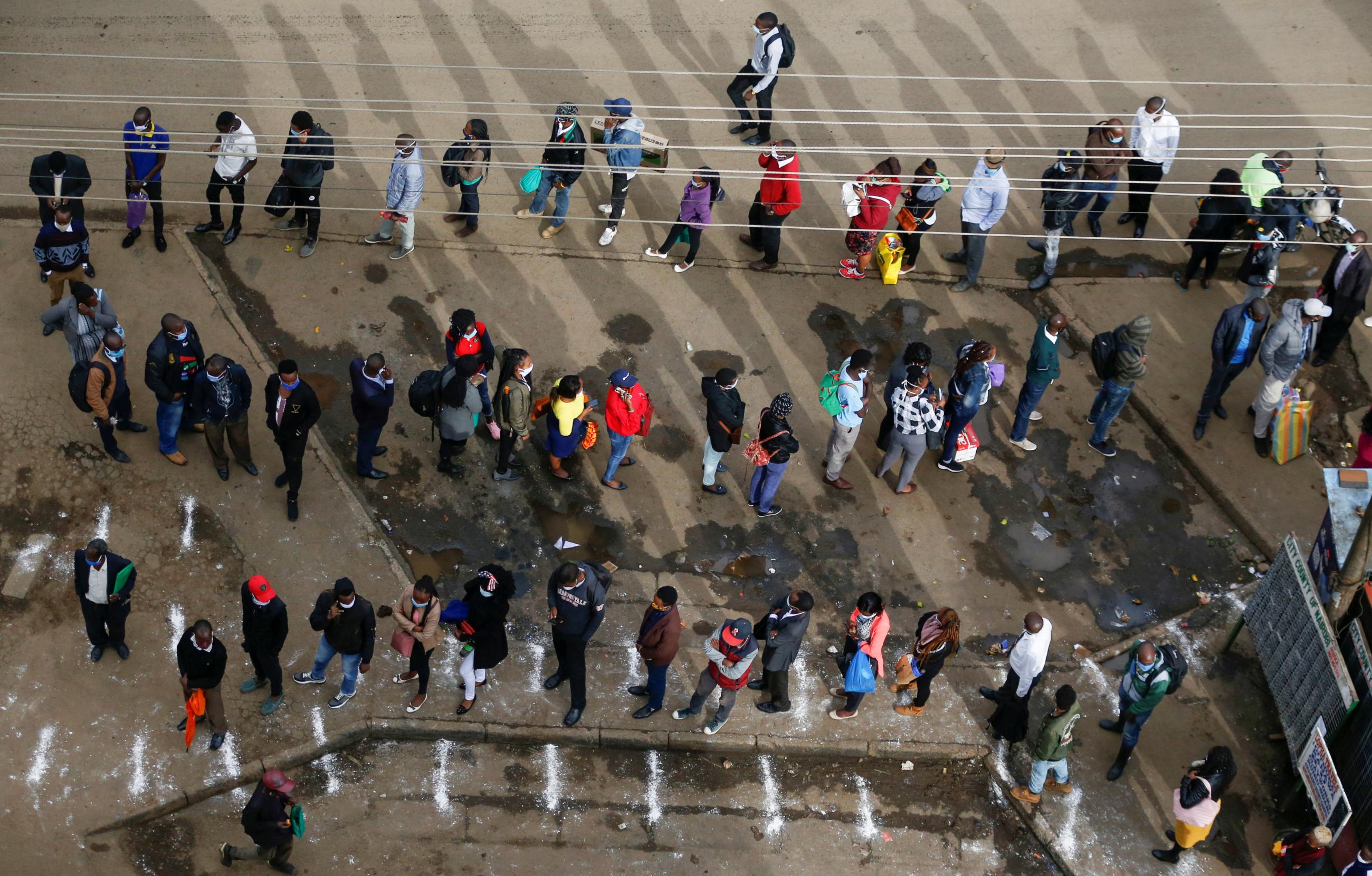 Residents are seen following social distancing rules while they queue for public transport before a curfew, as a measure to contain the spread of COVID-19, in downtown Nairobi, Kenya, in April 2020.