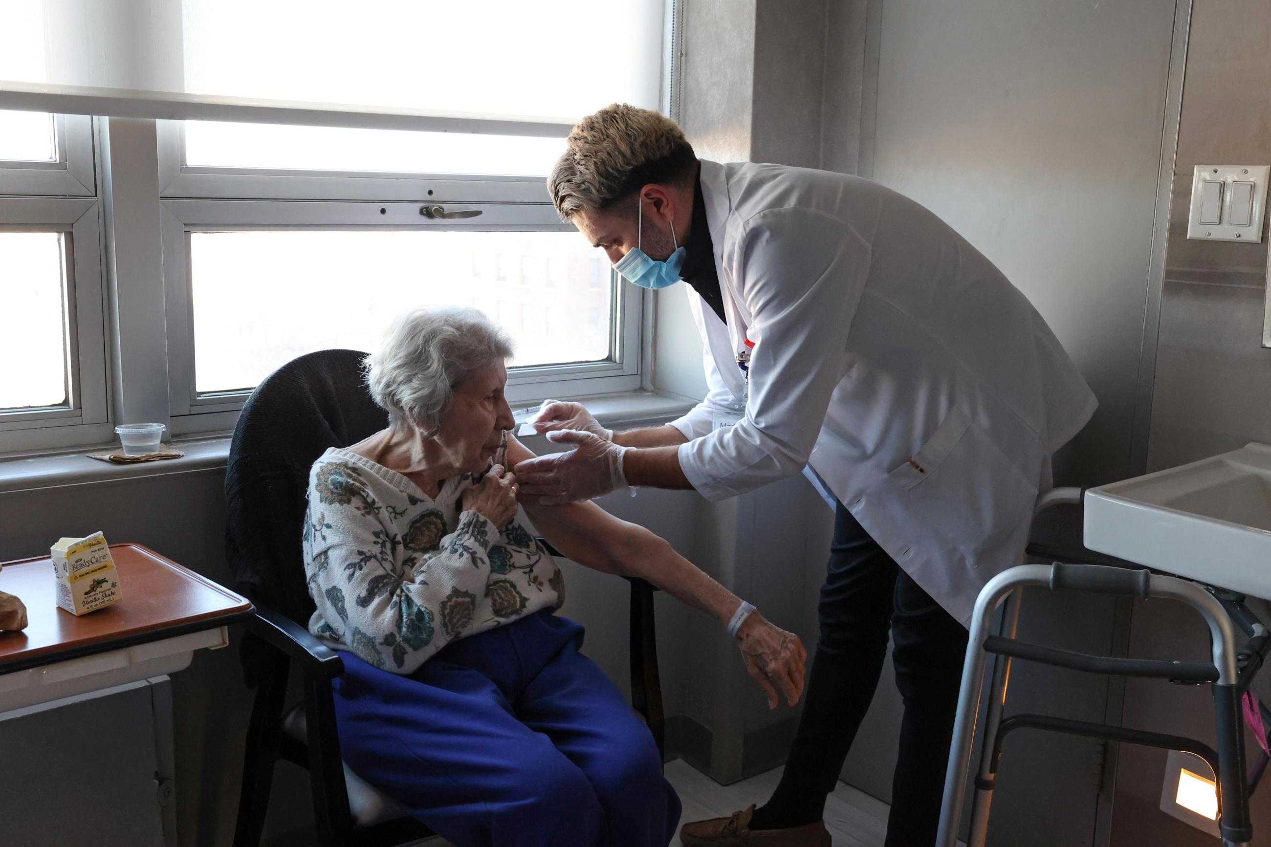 A nursing home resident receives a shot of the COVID-19 vaccine.