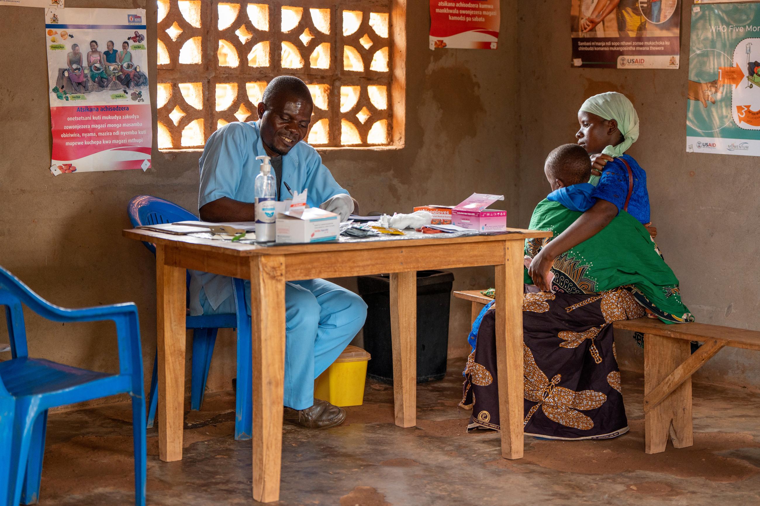 Health worker James Chinomba writes in details of a child after testing for malaria.