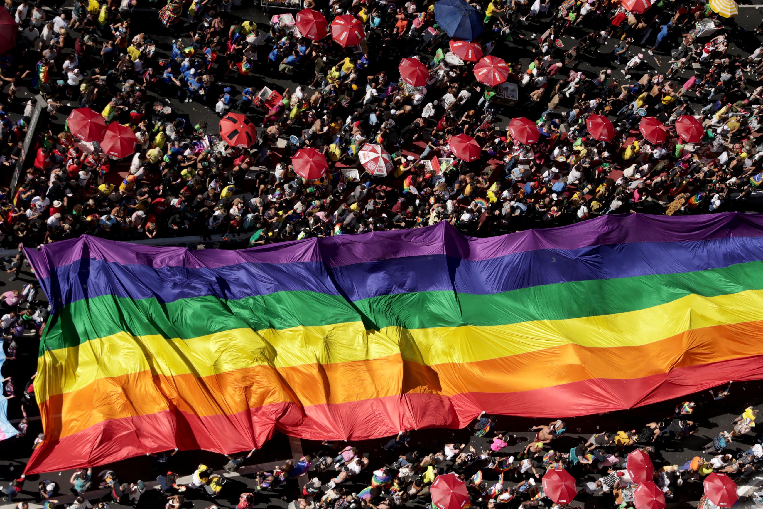 People attend a march through Paulista Avenue to celebrate LGBTQ+ rights during the annual Pride parade.