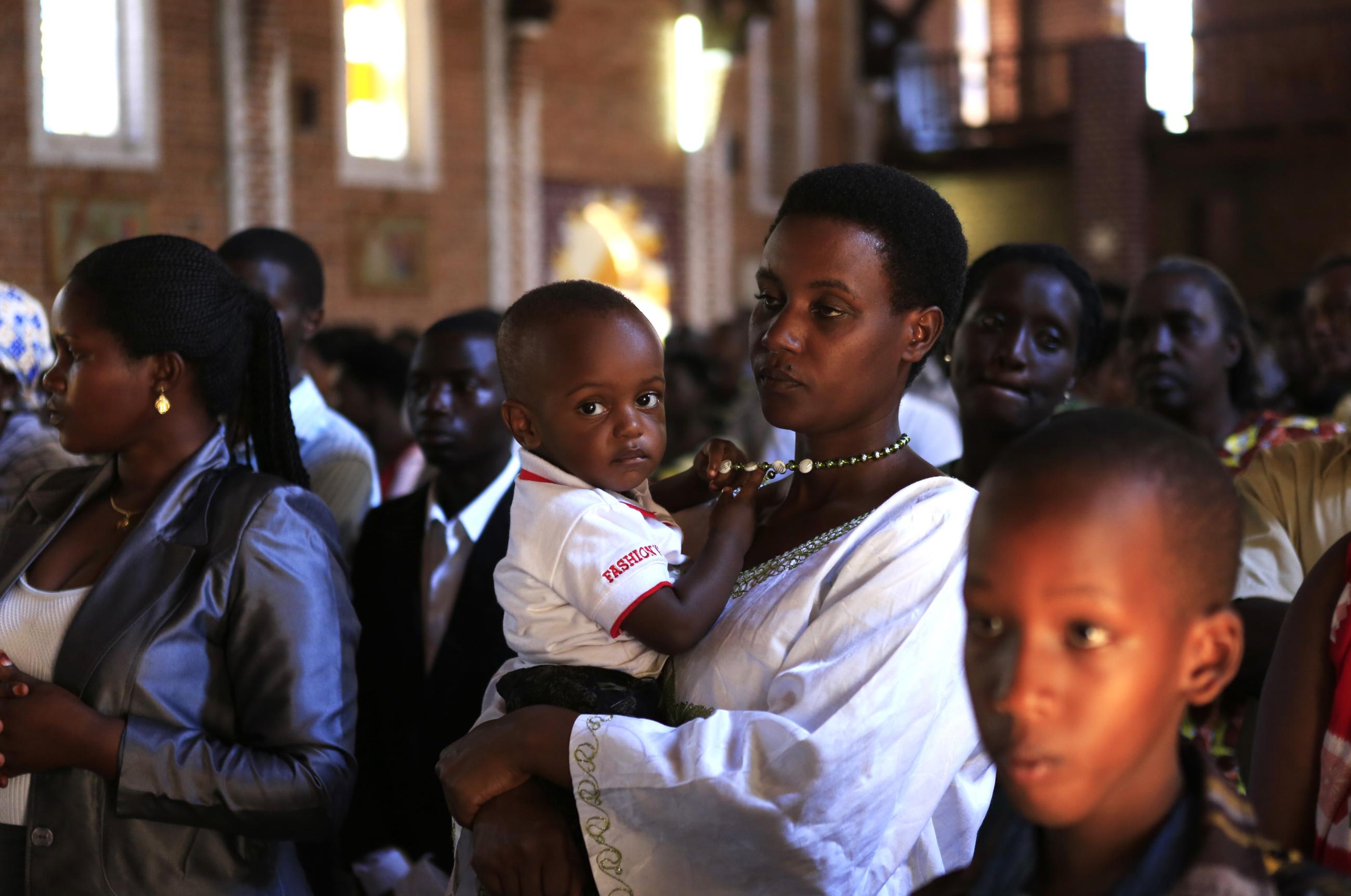 A woman holds her baby during a church service ahead of the commemoration of the 20th anniversary of the genocide.