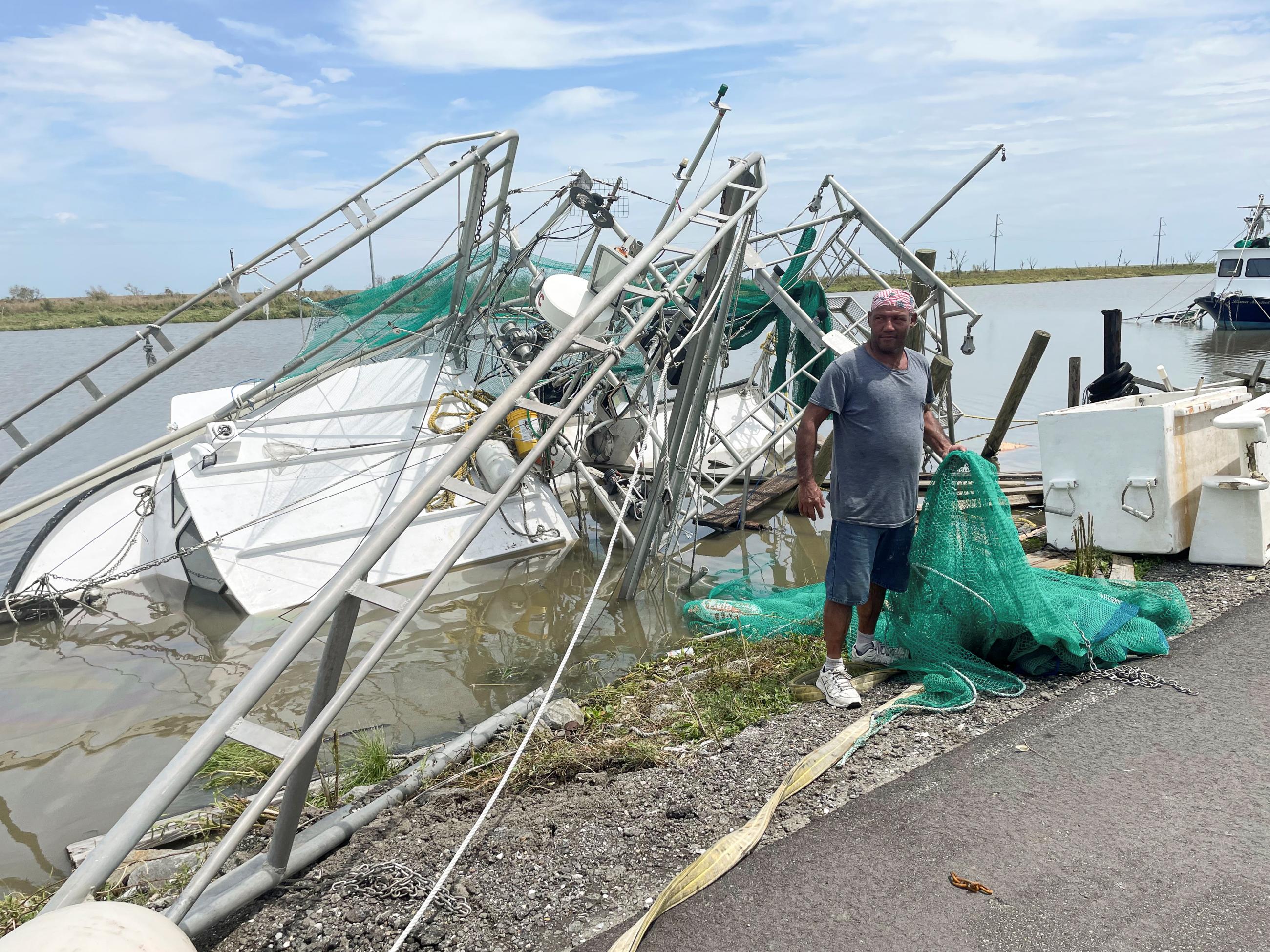 A man surveys the damage to homes and shrimp boats after Hurricane Ida made landfall.