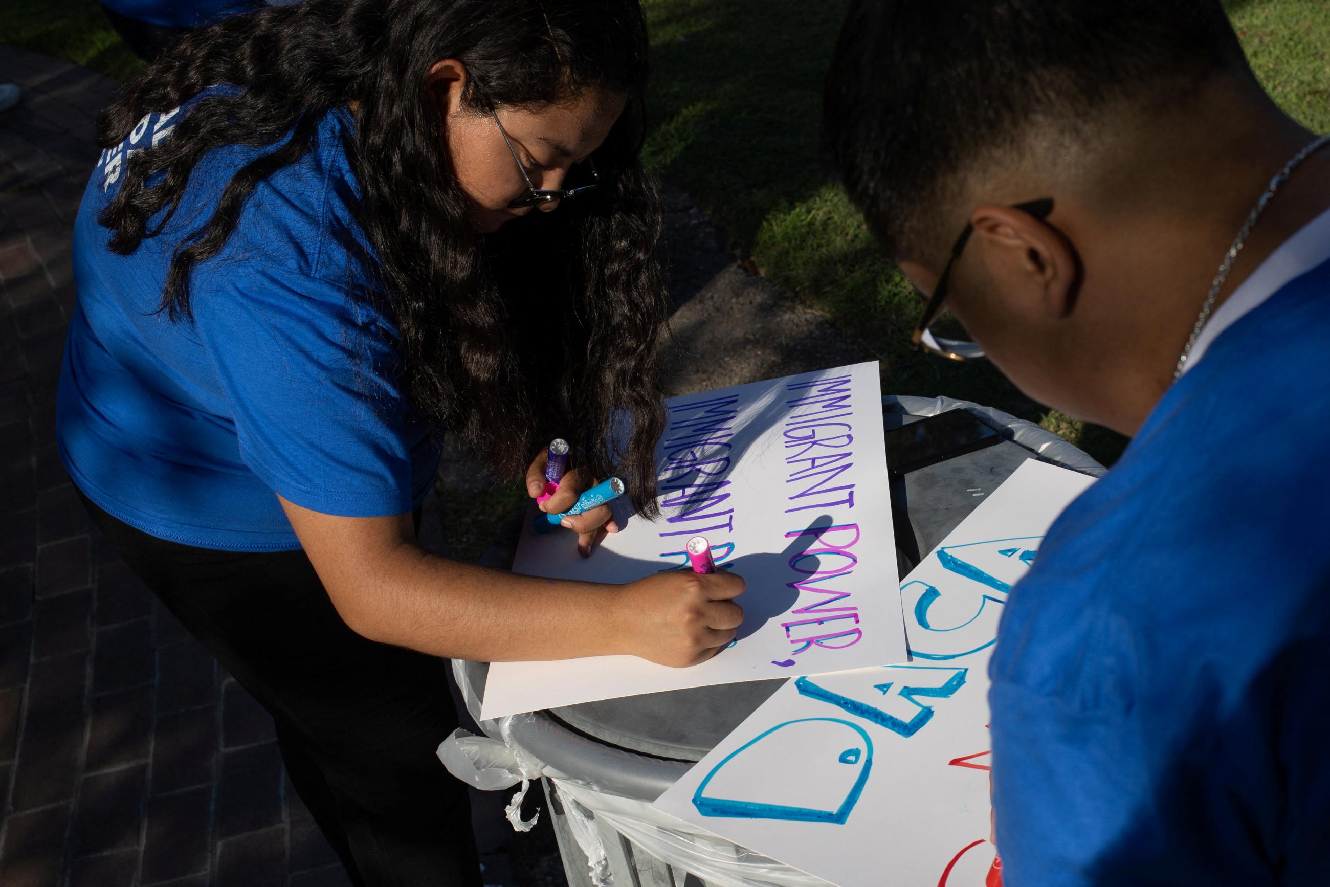 Nereida Bobadilla and Samuel Cano draw placards in support of the Deferred Action for Childhood Arrivals policy