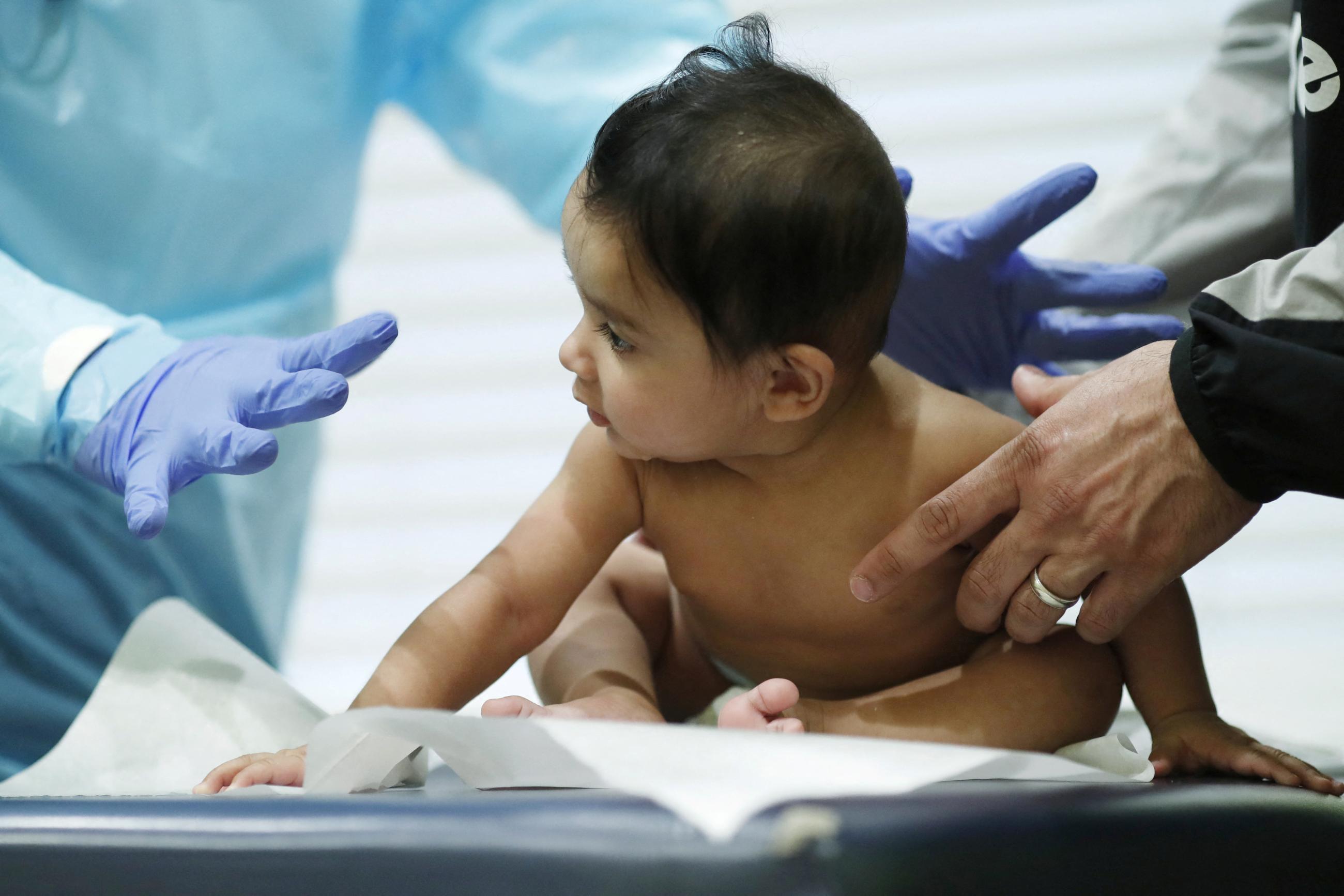 Greg Gulbransen, MD,  performs a routine checkup on a baby at his pediatric practice.