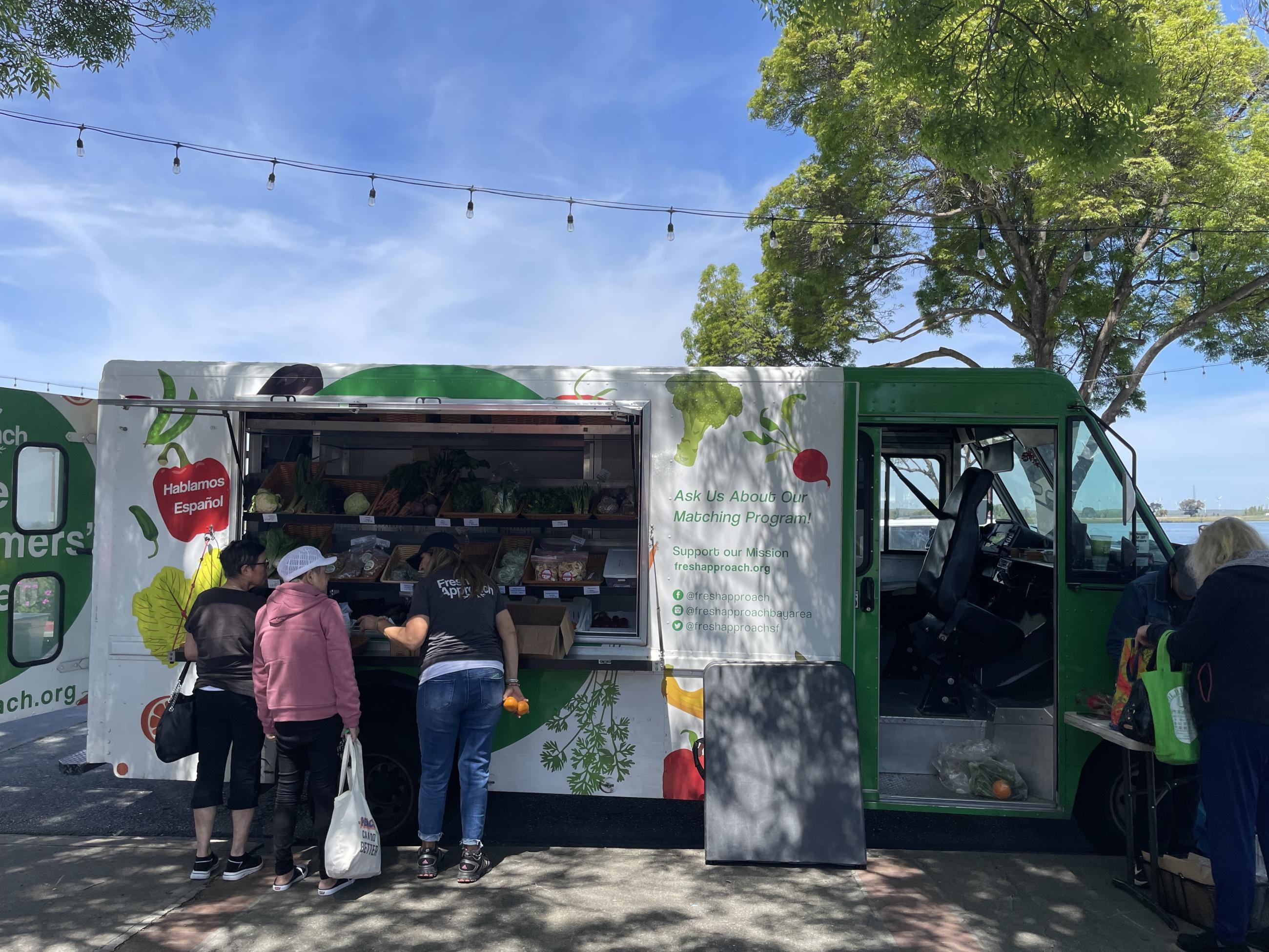Customers shop at the Fresh Approach mobile farmer's market in Antioch, California.
