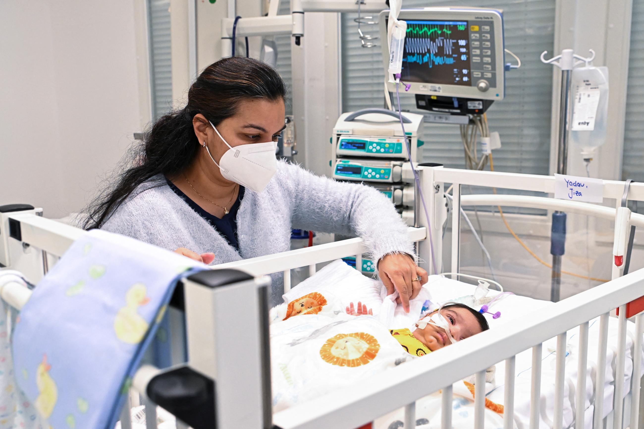 A mother watches her child who is suffering from an RSV infection, at the Asklepios Clinic's pediatric intensive care unit, in Sankt Augustin, Germany, on December, 6, 2022.