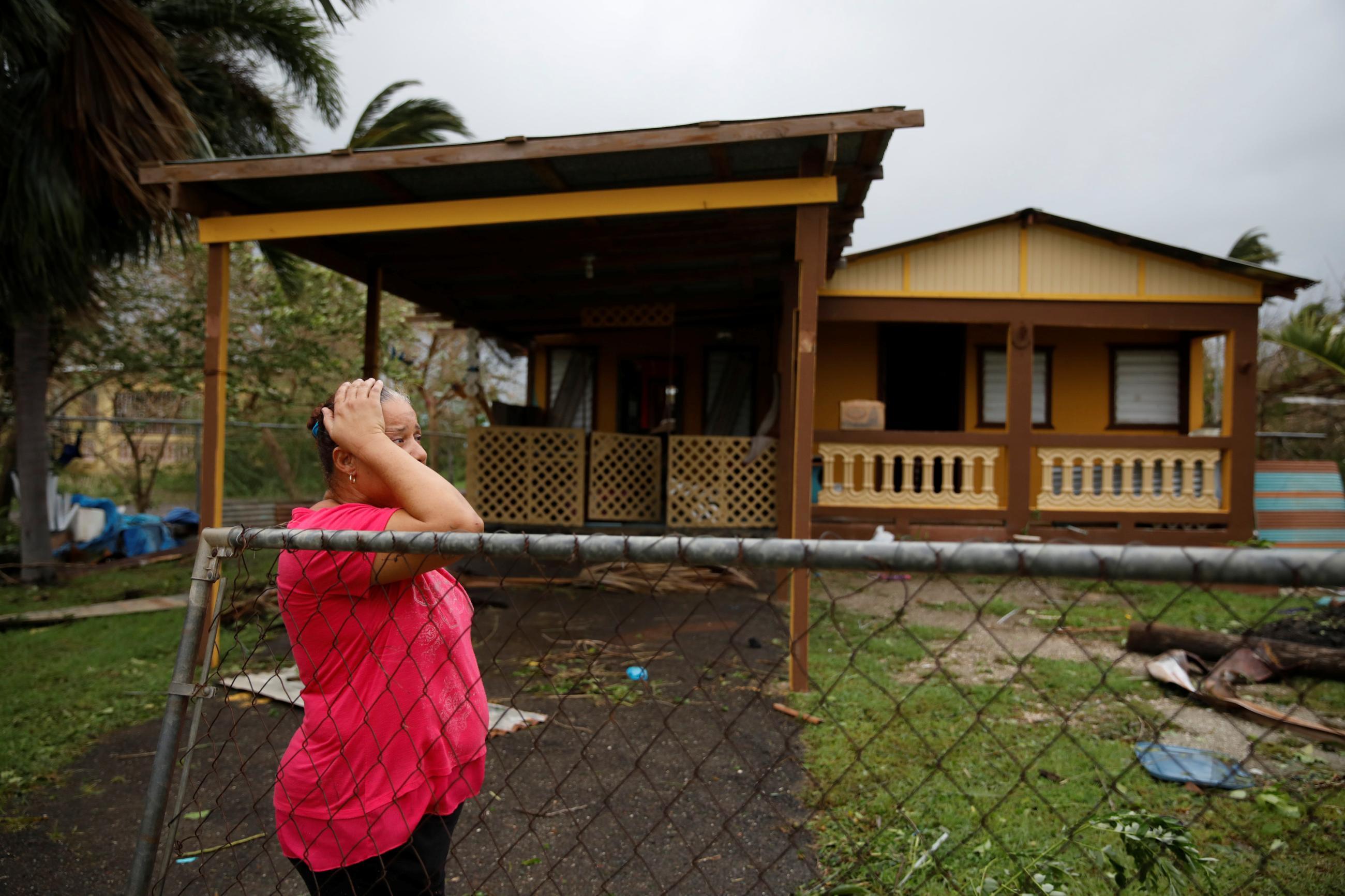 A woman reacts while looking at the damage to her house after the area was hit by Hurricane Maria.