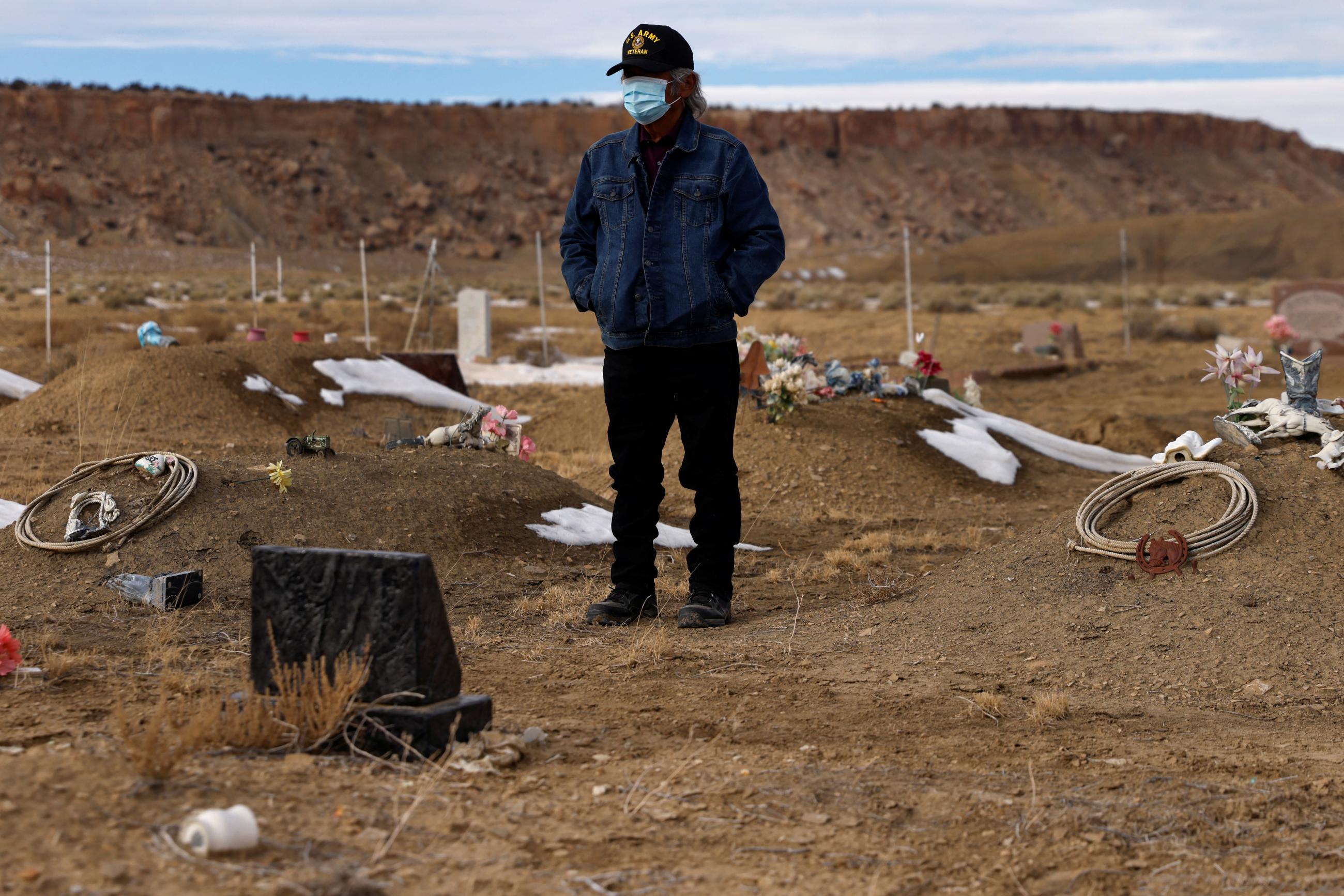 Wallace Buck stands alone waiting for the burial of his sons, who both died from complications of COVID-19. at the Sanostee chapter of the Navajo nation.