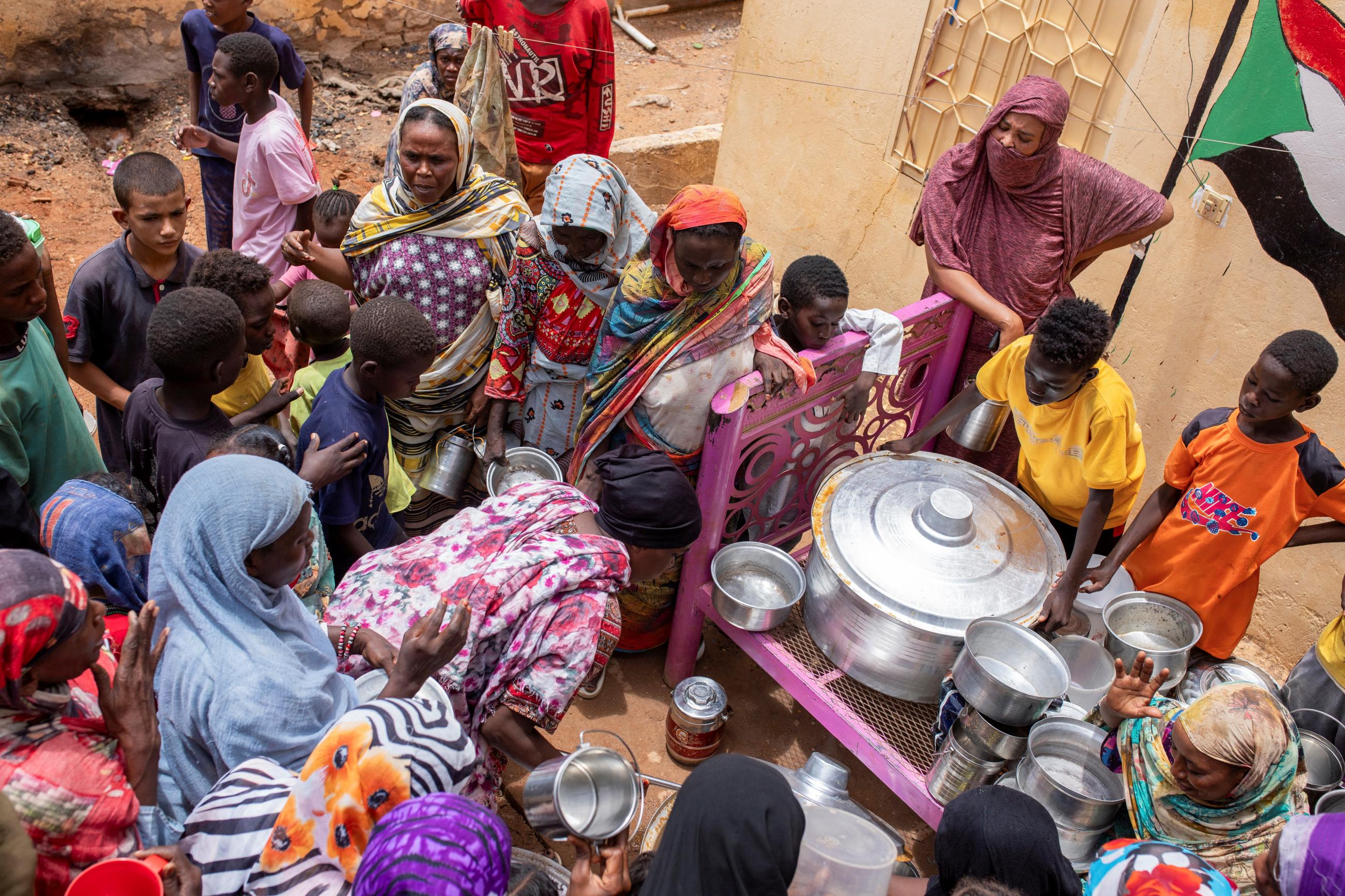 Women from community kitchens distribute meals to those who are affected by conflict and extreme hunger and out of reach of international aid efforts, in Omdurman, Sudan, on July 27, 2024. 