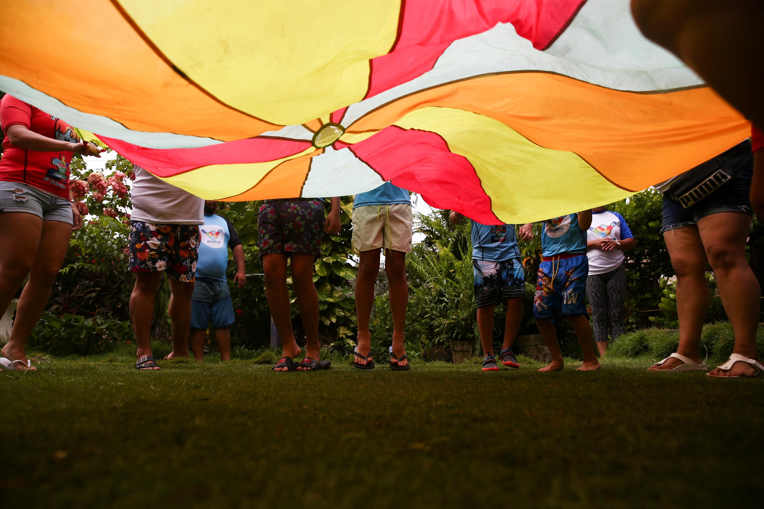 Children and instructors participate in a game prior to surfing, as part of the Surftismo program, an alternative therapy for children on the autism spectrum, in Chiltiupan, El Salvador, on August 14, 2022.