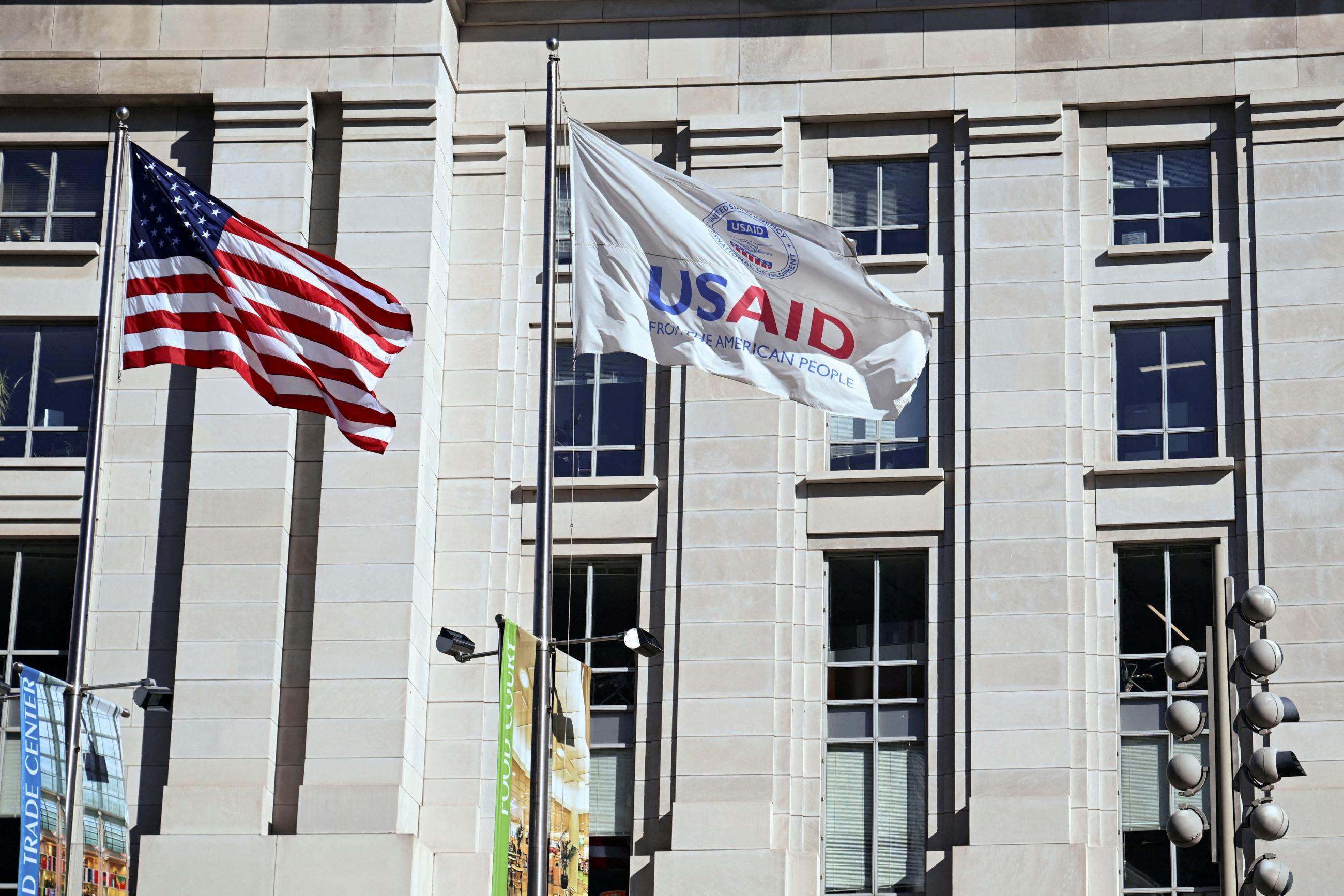 An American flag and USAID flag fly outside the USAID building in Washington, DC, on February 1, 2025. 
