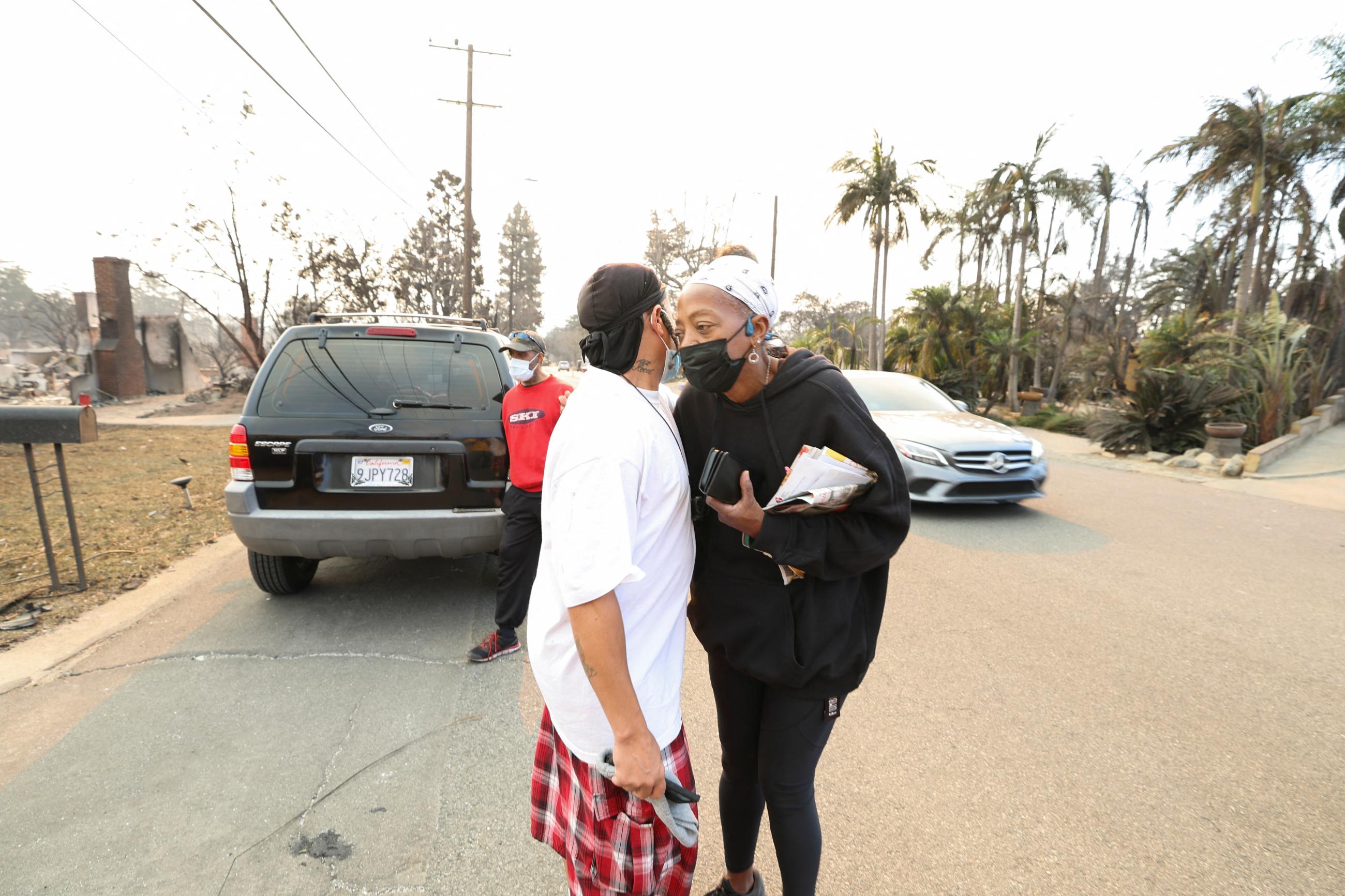Kay Young, a homeowner whose house was destroyed after the Eaton Fire tore through a neighborhood, embraces a neighbor, while a pair of massive wildfires menacing Los Angeles from the east and west were still burning uncontained, in Altadena, California, U.S. January 9, 2025.