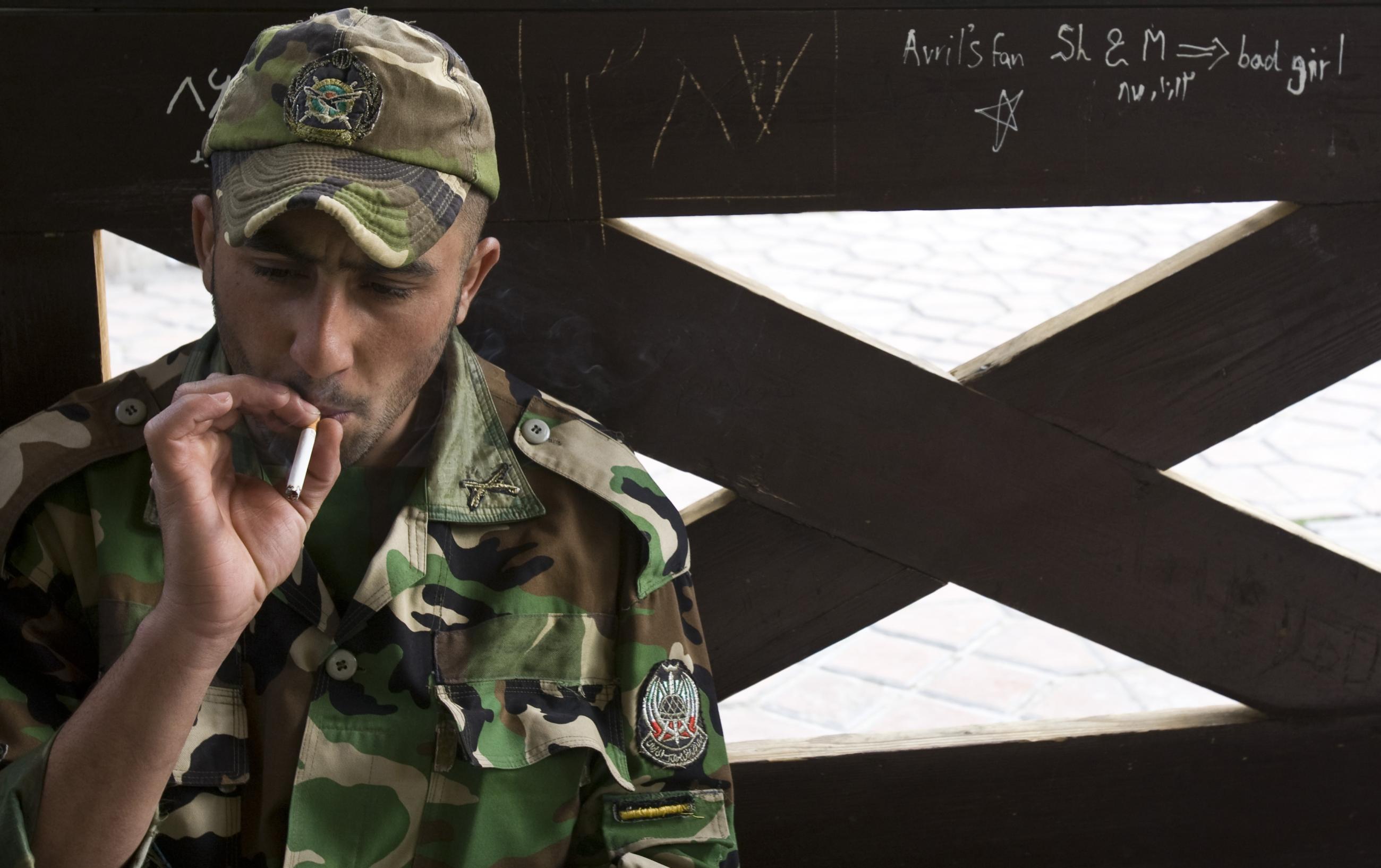 A member of the Iranian army smokes as he rests at a park in central Tehran, April 9, 2009. 