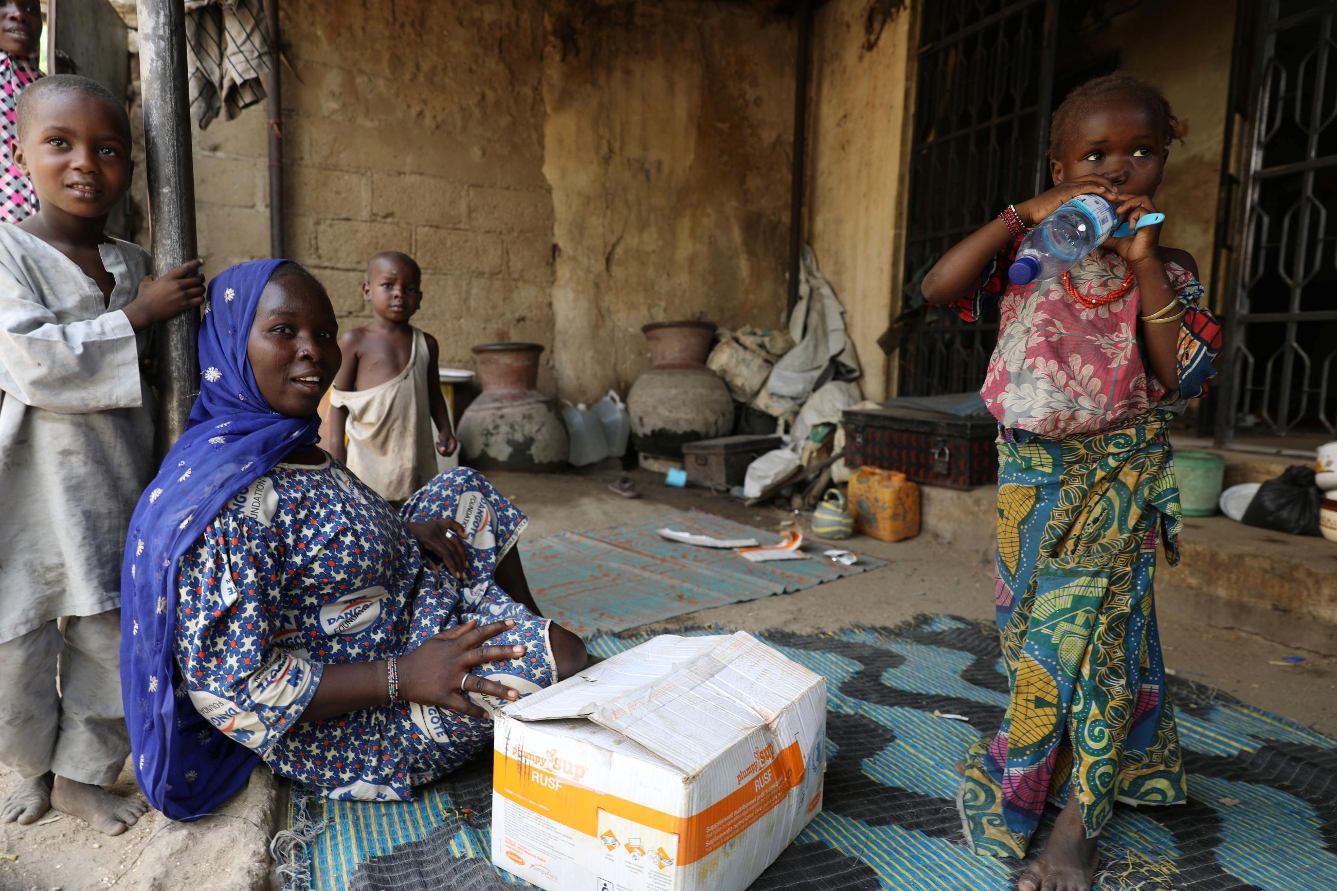 A family is seen with a package of food supplement received from World Food Program at the Banki IDP camp, in Borno, Nigeria, on April 26, 2017. 