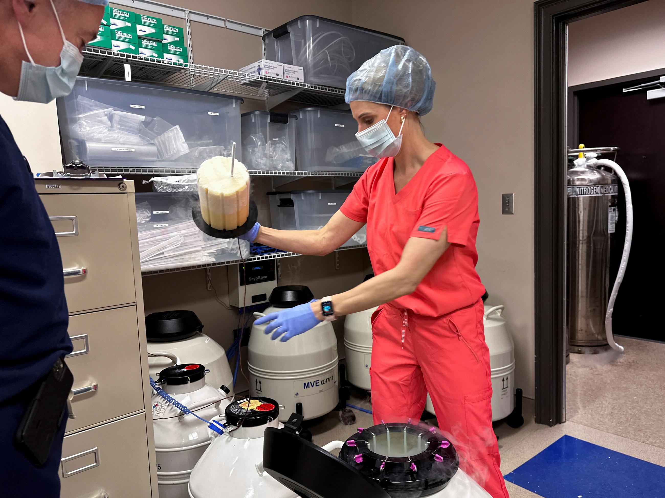 Medical director for Huntsville Reproductive Medicine, P.C., looks on as a nurse practitioner opens an IVF cryopreservation dewar, in Madison, Alabama, on March 4, 2024.