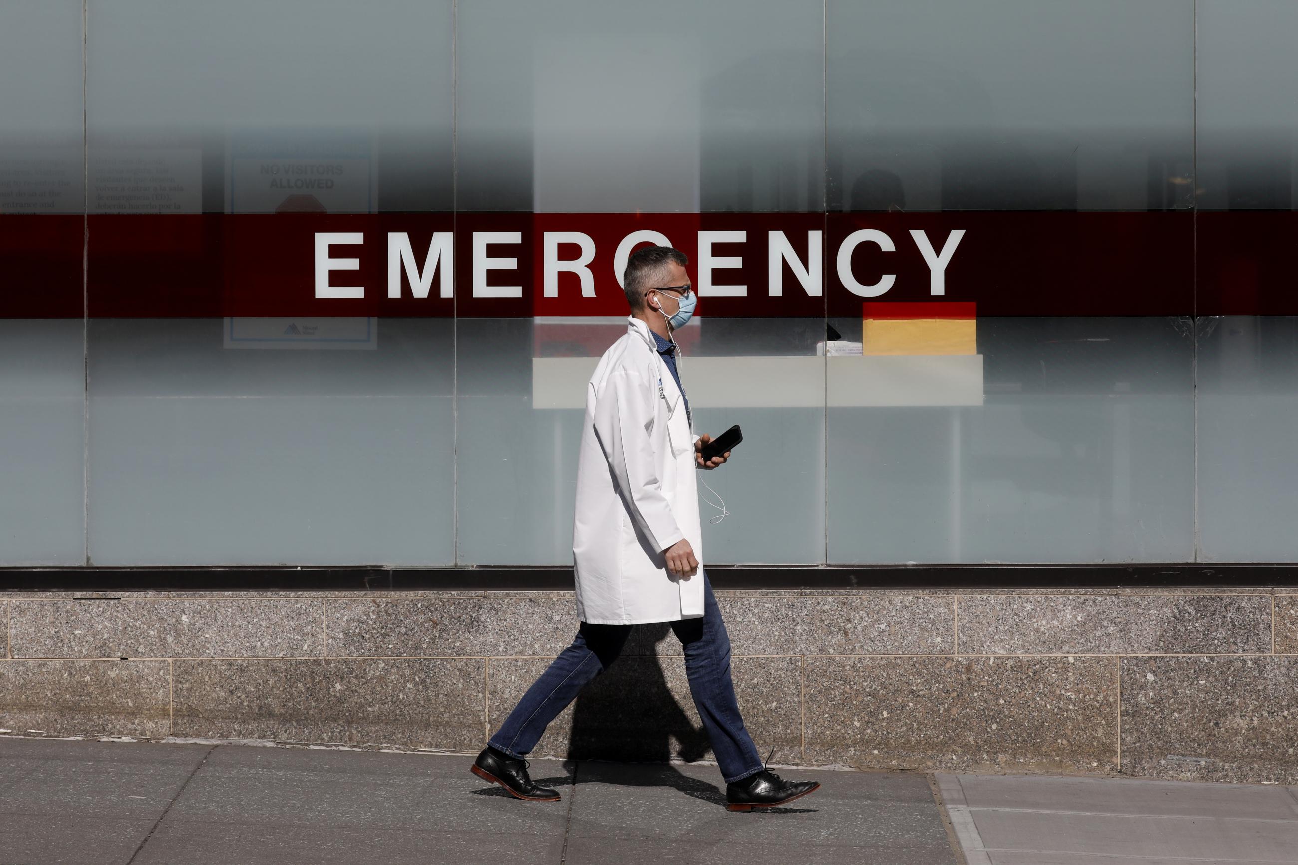A doctor wears a protective mask as he walks outside Mount Sinai Hospital, in Manhattan, New York City, New York, on April 1, 2020. 