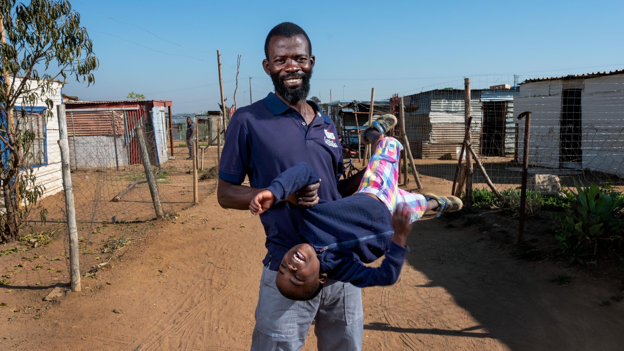 A man is pictured with his young son outside his home in Pretoria, South Africa.