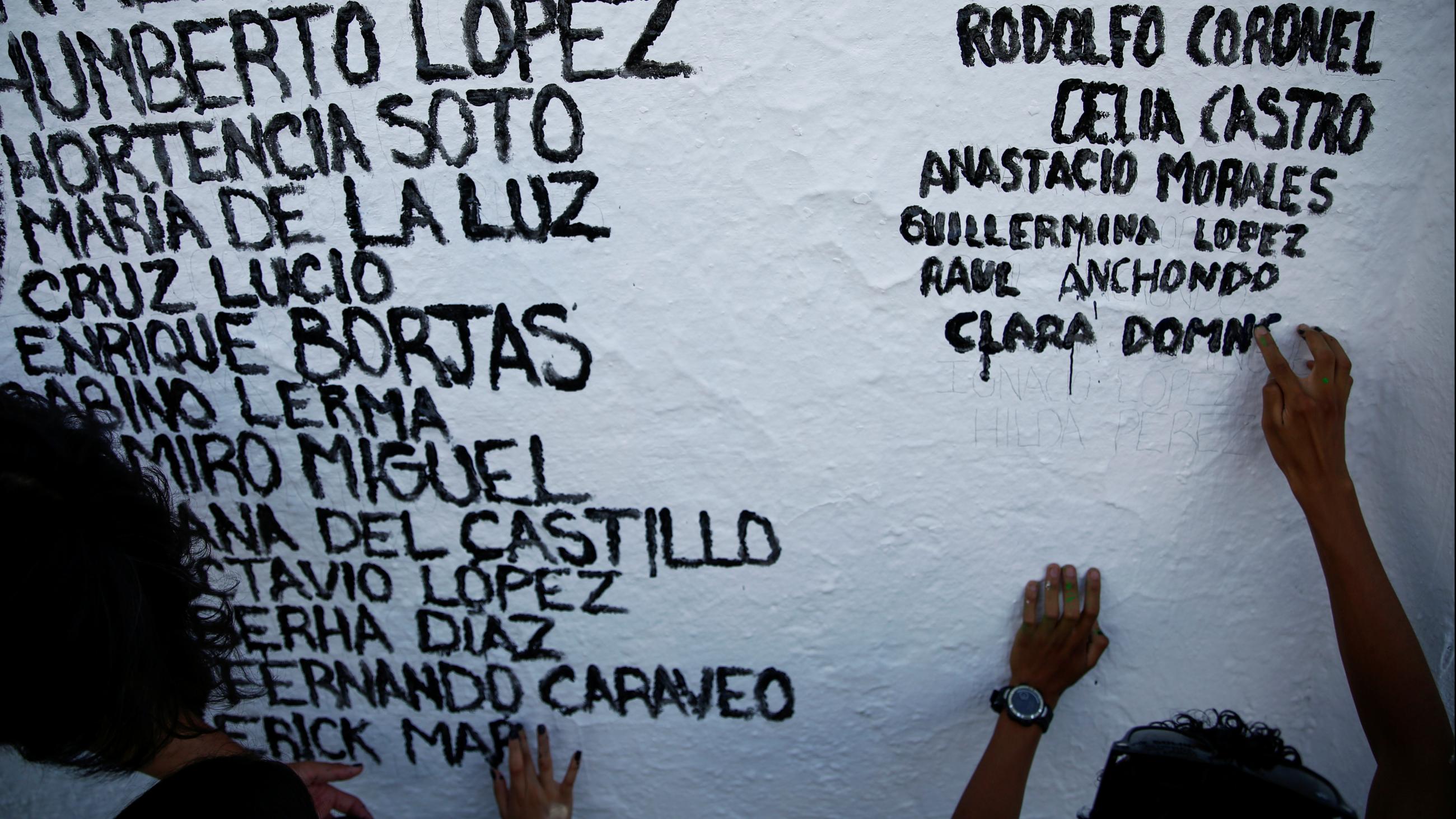 The names of people who died from the coronavirus disease are painted on a wall by members of the non-profit organization Ataraxia, in Ciudad Juarez, Mexico, on July 31, 2021.