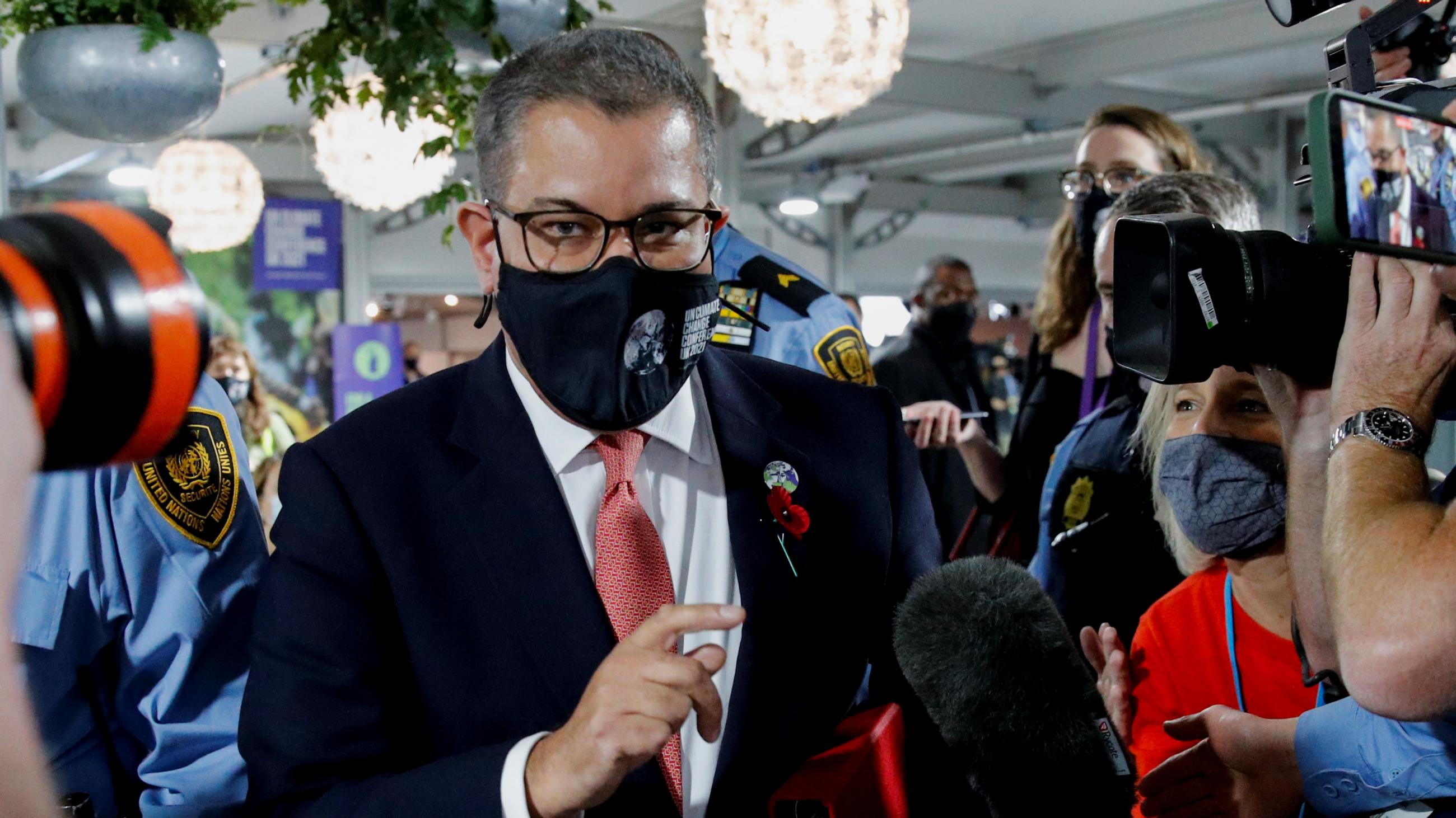 The President of the UN Climate Change Conference (COP26), Alok Sharma, talks to the media as he walks through the conference center in Glasgow.
