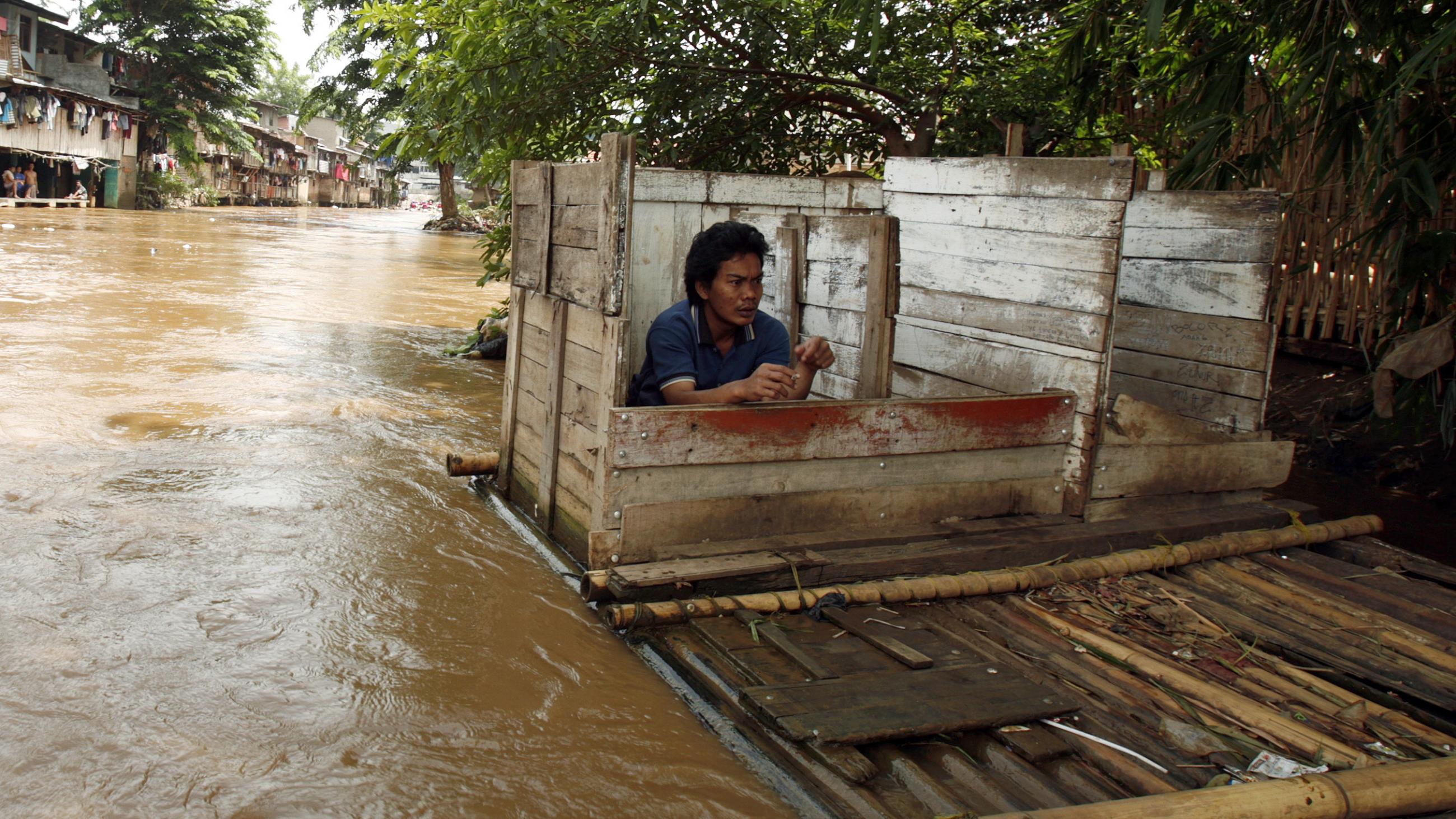 After a period of intense flooding, a man uses a floating public toilet on the Ciliwung river bank in Jakarta, Indonesia, on December 28, 2006.