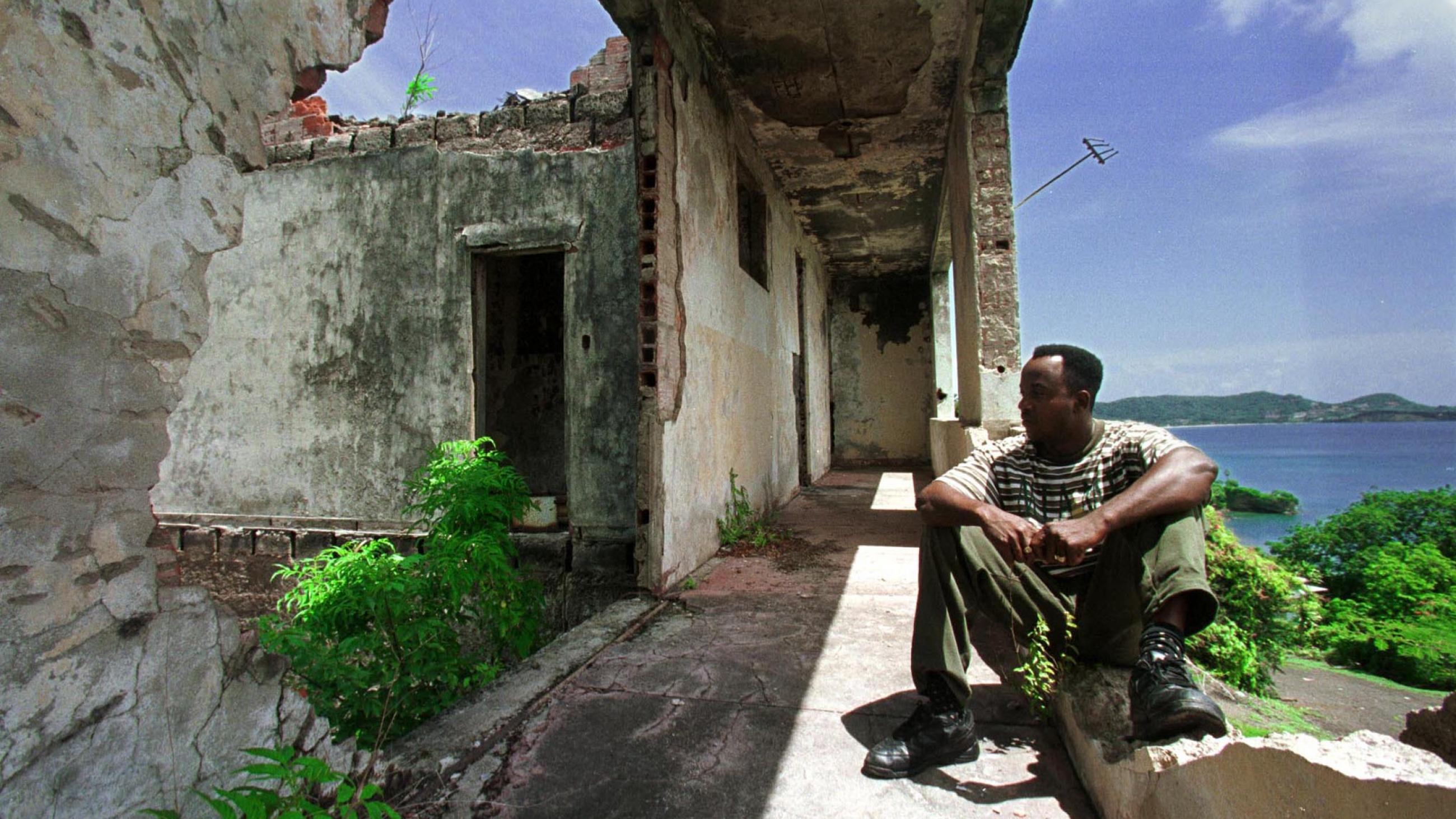 A Grenadian man sits August 1, in the former prime minister's building which was bombed by American troops in the U.S. invasion on Grenada in 1983