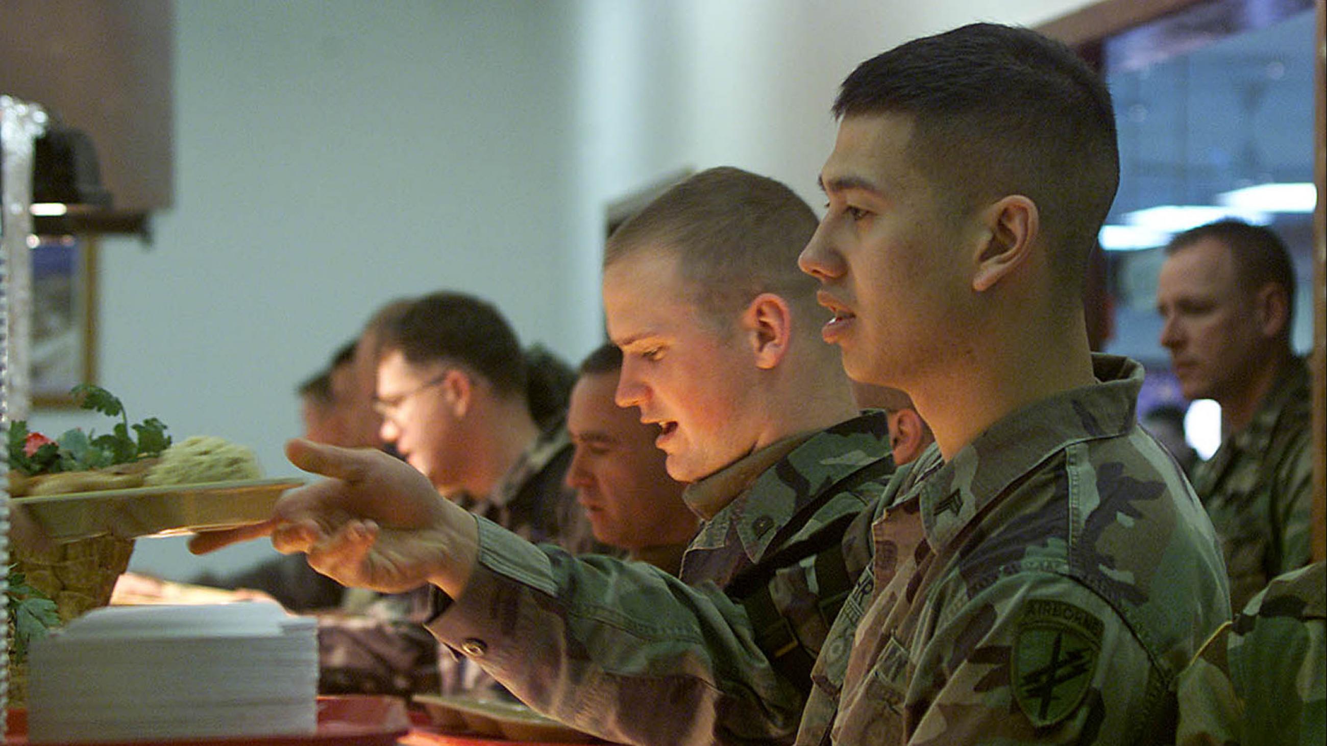 U.S. peacekeepers at camp Bondsteel in southern Kosovo line up to pick a rich selection of dishes, including roast turkey with giblet gravy, during their celebration of Thanksgivings day on Thursday November 22, 2001.