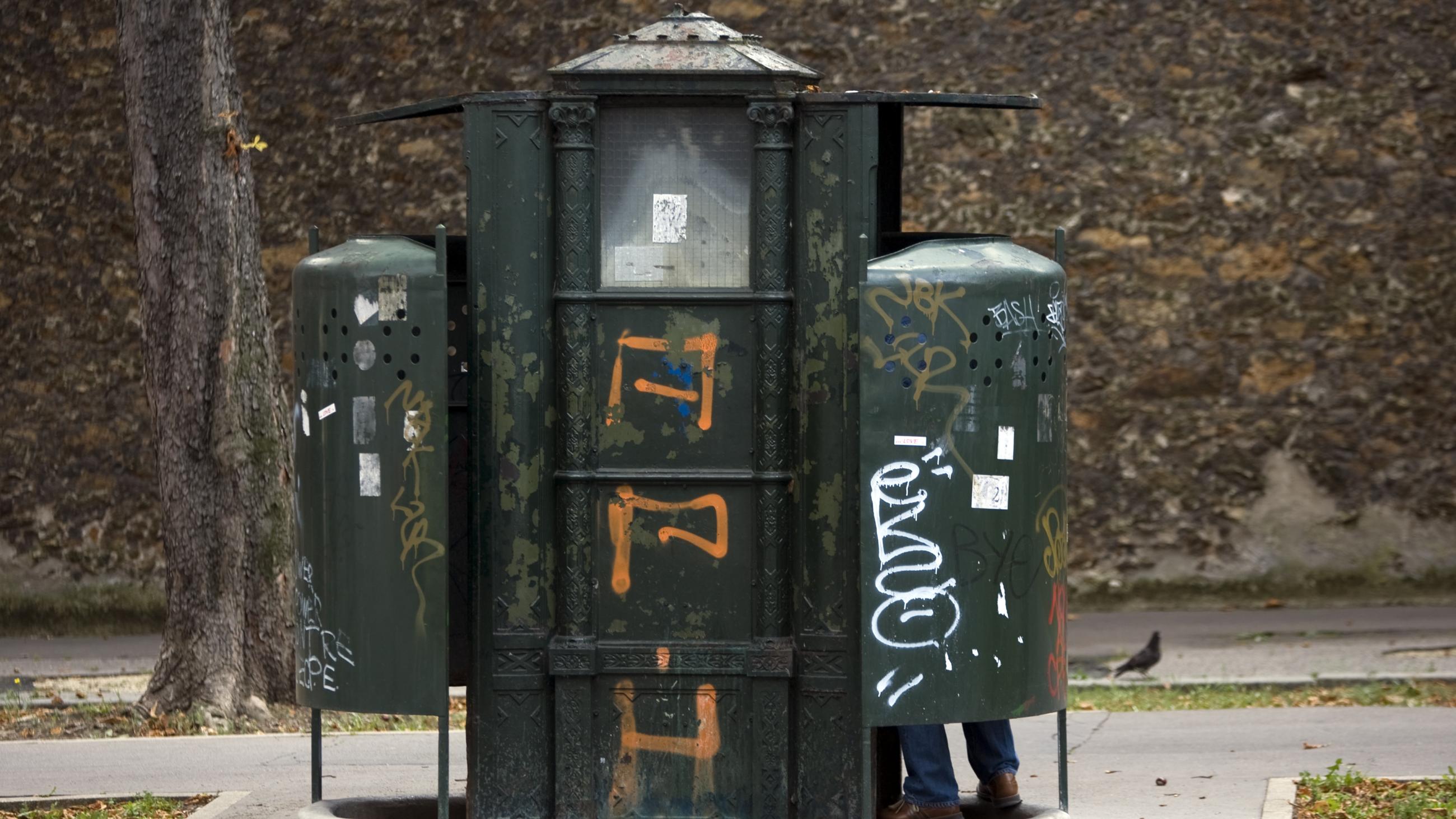 A driver uses the last surviving vespasienne (public urinals) on the boulevard Arago in