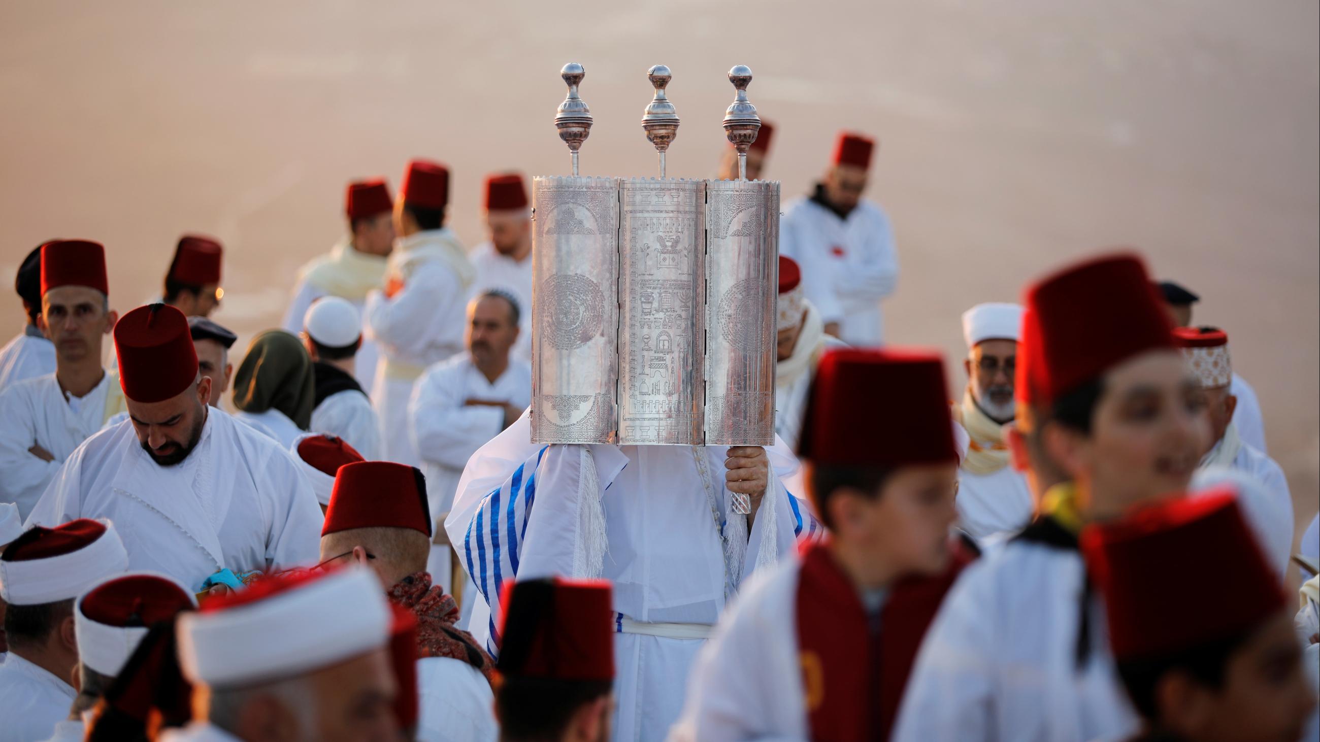 A member of the Samaritan sect holds a Torah scroll during a traditional pilgrimage marking the holiday of Sukkot, or Feast of Tabernacles, atop Mount Gerizim near Nablus in the occupied West Bank, Israel, on October 20, 2021.