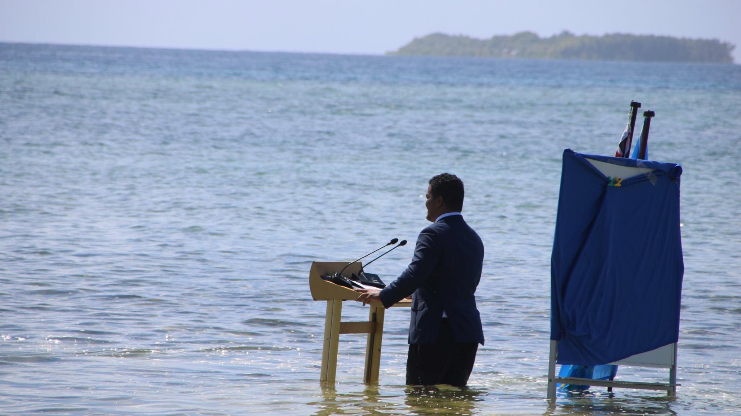 Tuvalu's Minister for Justice, Communication & Foreign Affairs Simon Kofe gives a COP26 speech while standing knee-deep in the ocean in Funafuti, Tuvalu, on November 5.