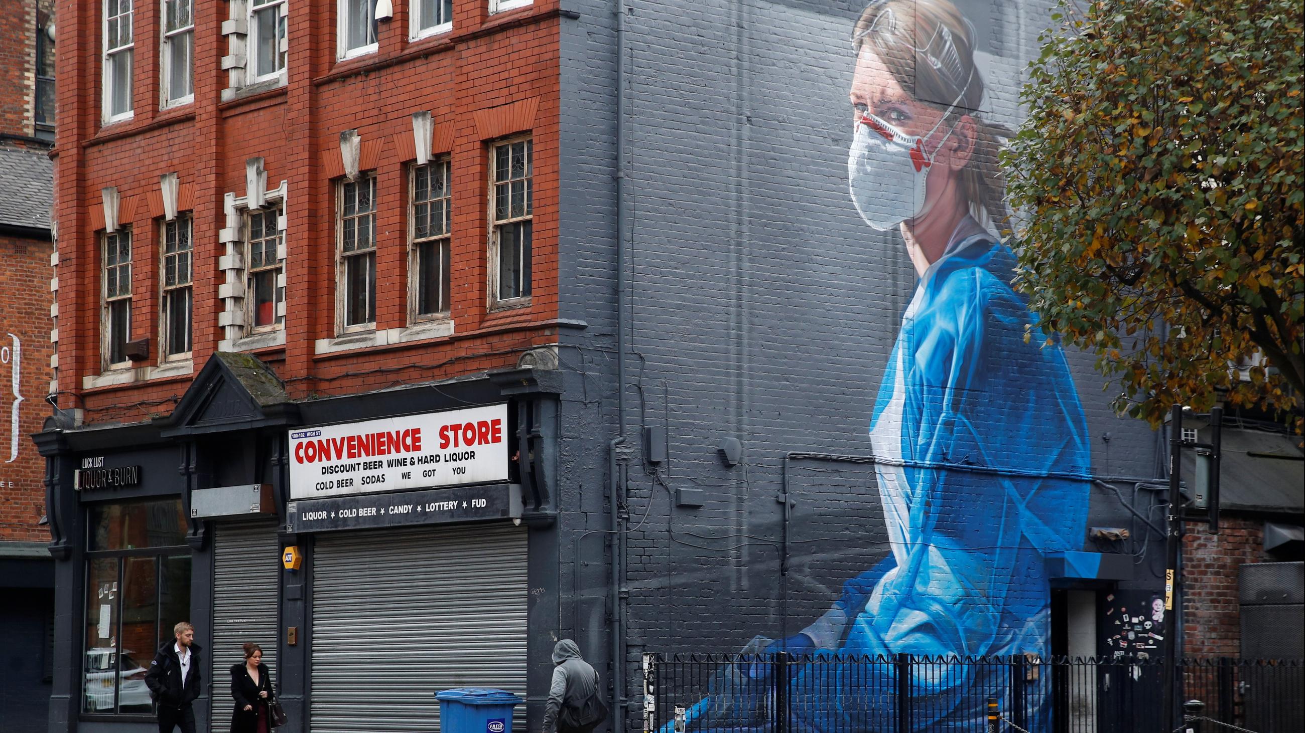 A mural of a health-care worker climbs three stories high along the side of a building in Manchester, United Kingdom, on October 19, 2020.