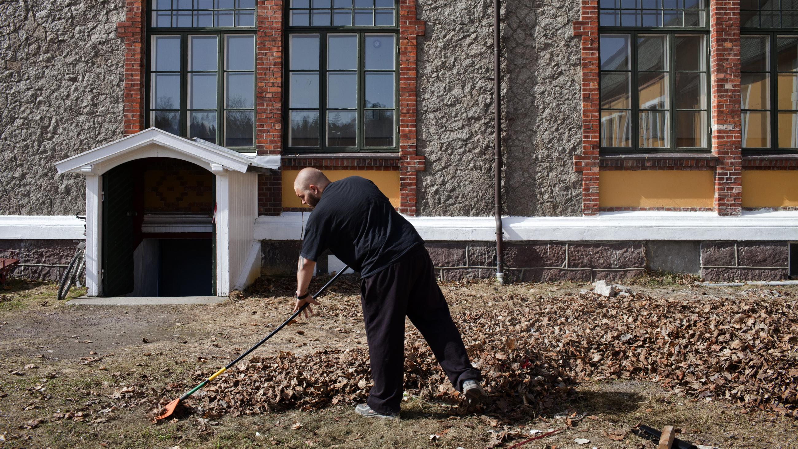 An inmate sentenced to ten months rakes leaves in Bastøy Prison in Horten, Norway on April 11, 2011