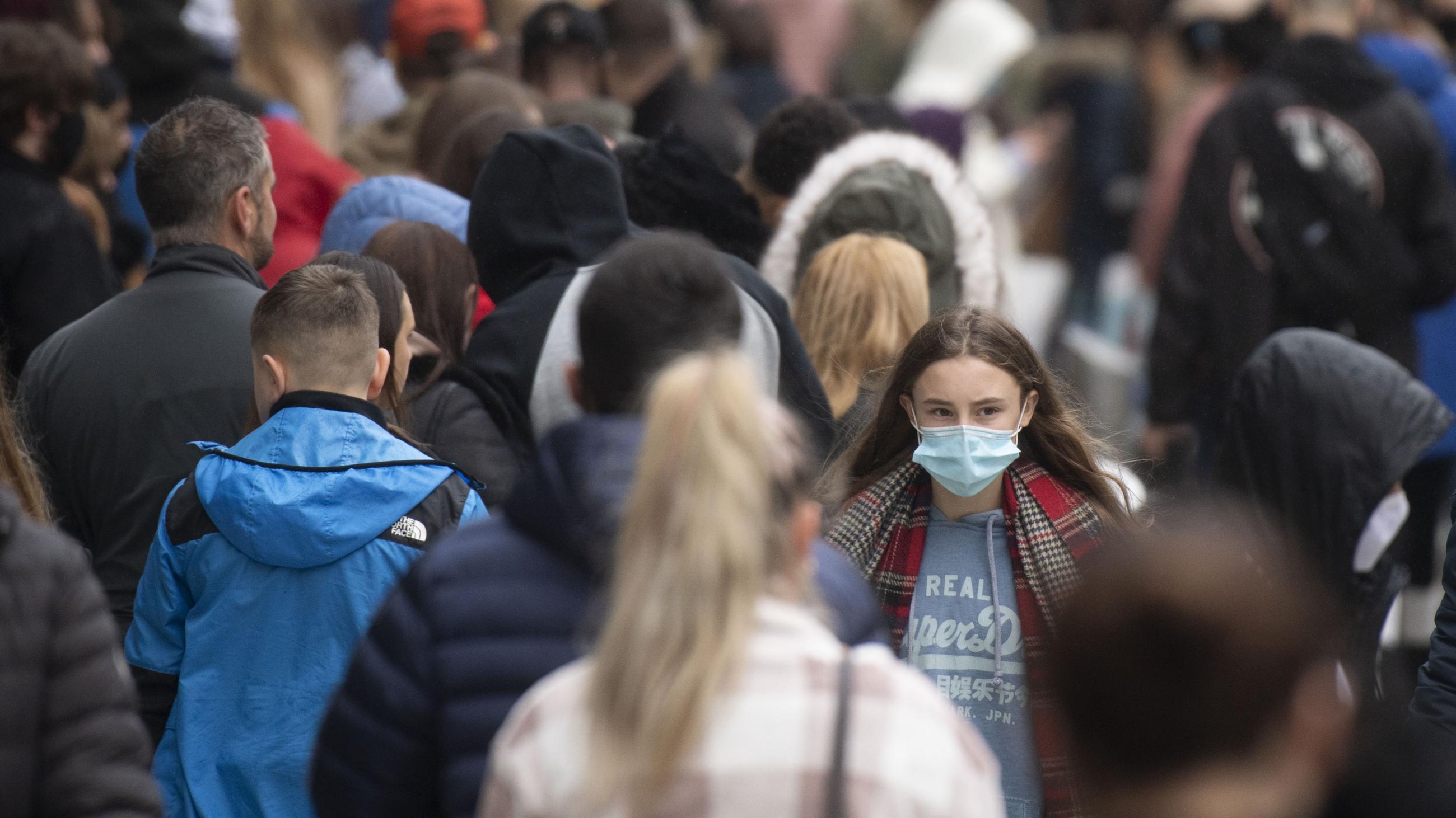 A woman wears a face mask on a busy Queen Street in Cardiff, Wales, United Kingdom on November 21, 2020. 
