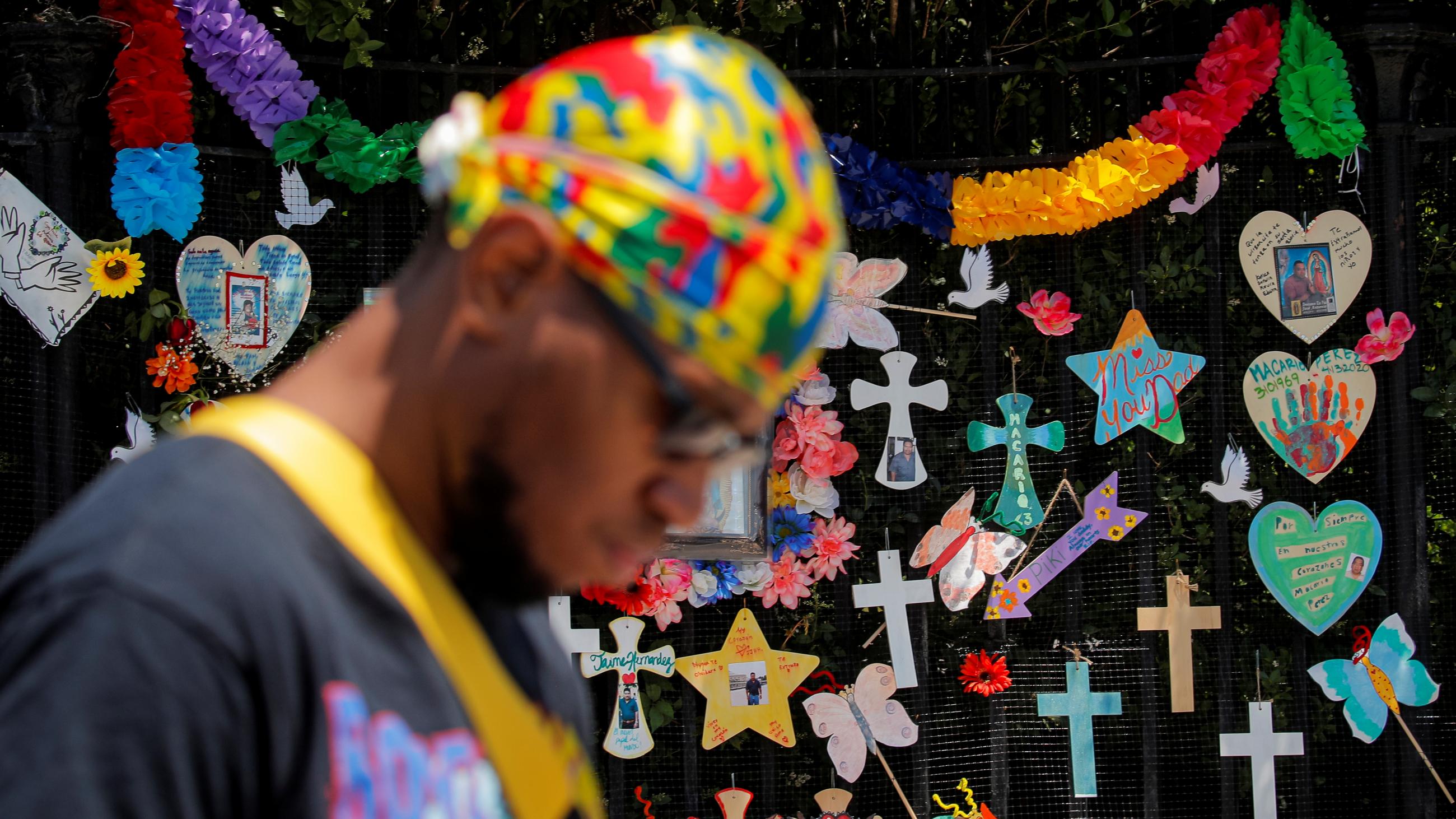 A man bows his head as he walks past a "Naming the Lost Memorials” site—memorials curated by artists and activists in memory of those who’ve died of COVID-19, at The Green-Wood Cemetery in Brooklyn, New York, on June 10, 2021.