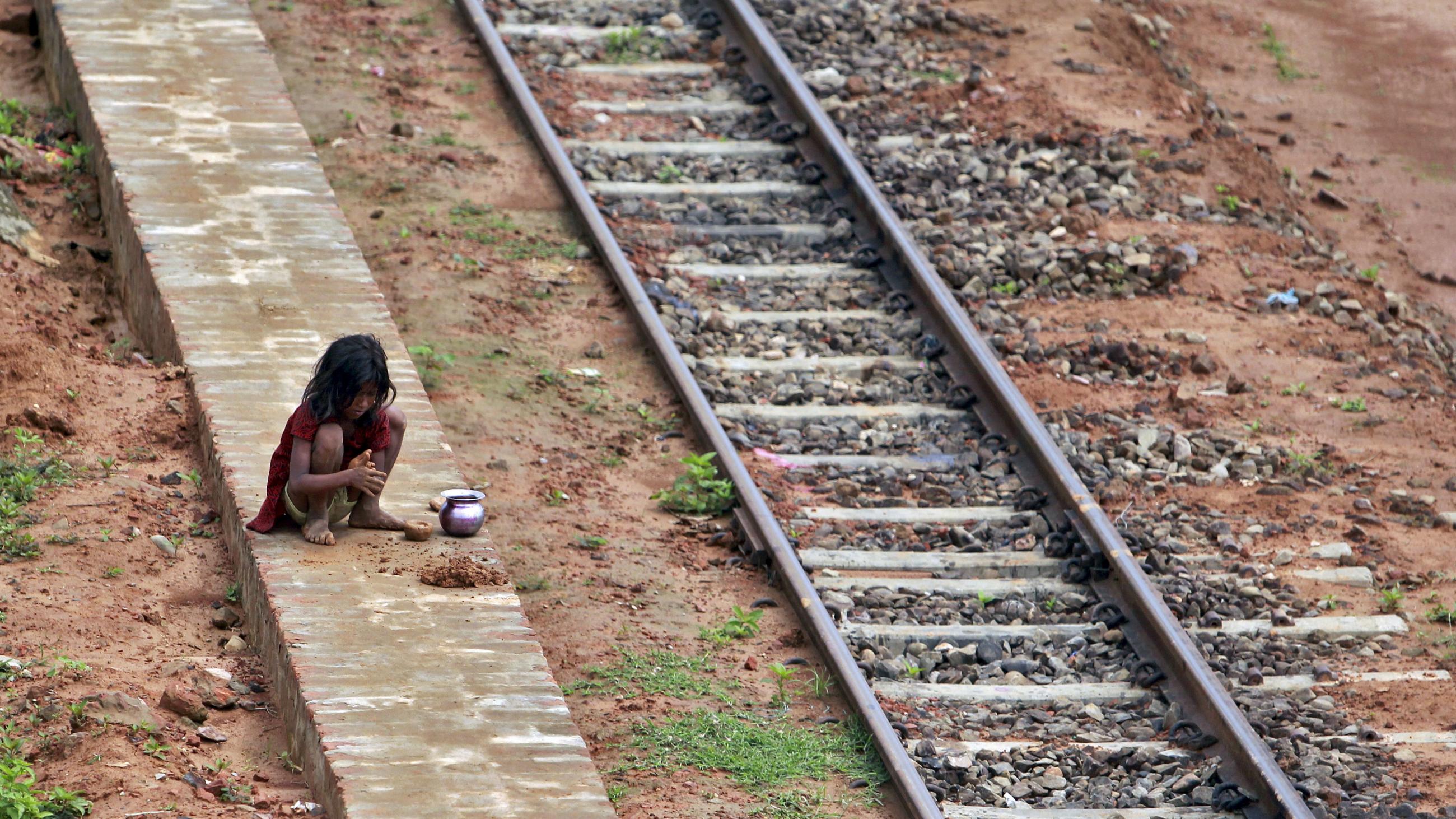 A girl plays with clay next to a railway track in Agartala, India on May 28, 2015.