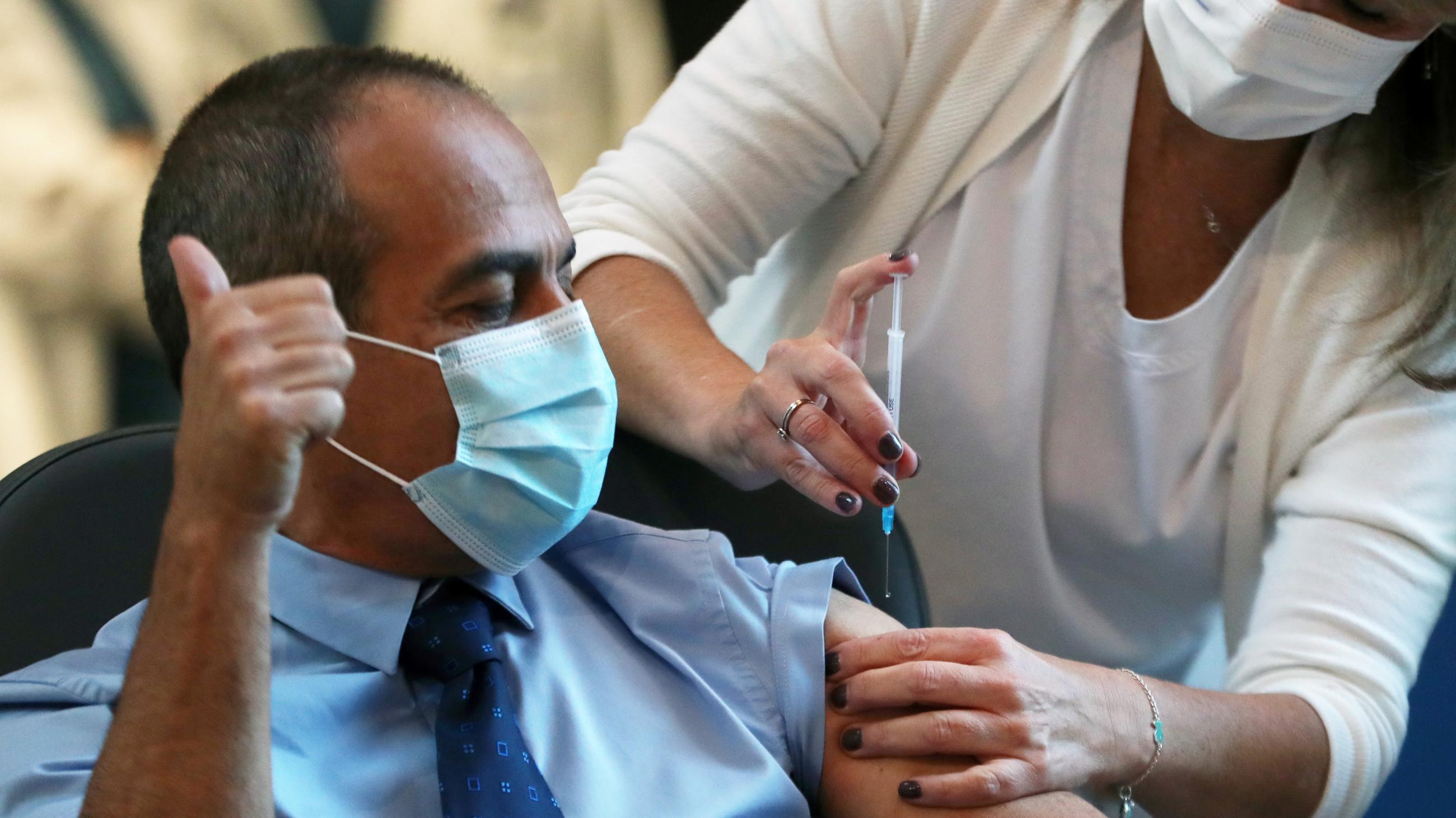 A medical worker vaccinates a man against the coronavirus disease as Israel kicks off a coronavirus vaccination drive, at Tel Aviv Sourasky Medical Center in Tel Aviv, Israel on December 20, 2020.