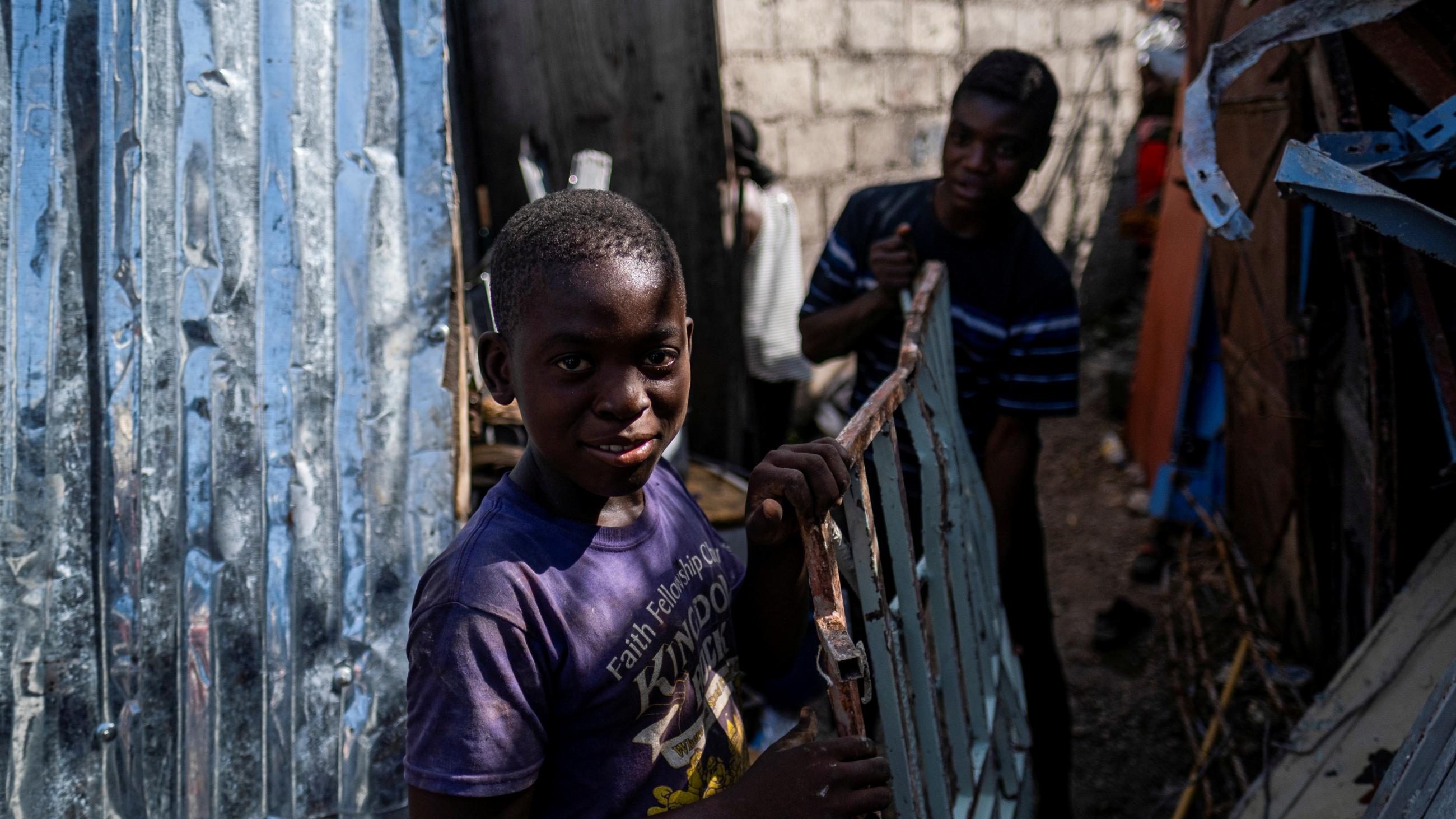 Boys working at a metal recycler carry metal scavenged from houses destroyed in a 7.2 magnitude earthquake in Les Cayes, Haiti, on August 14, 2021. Photo taken on August 21, 2021.