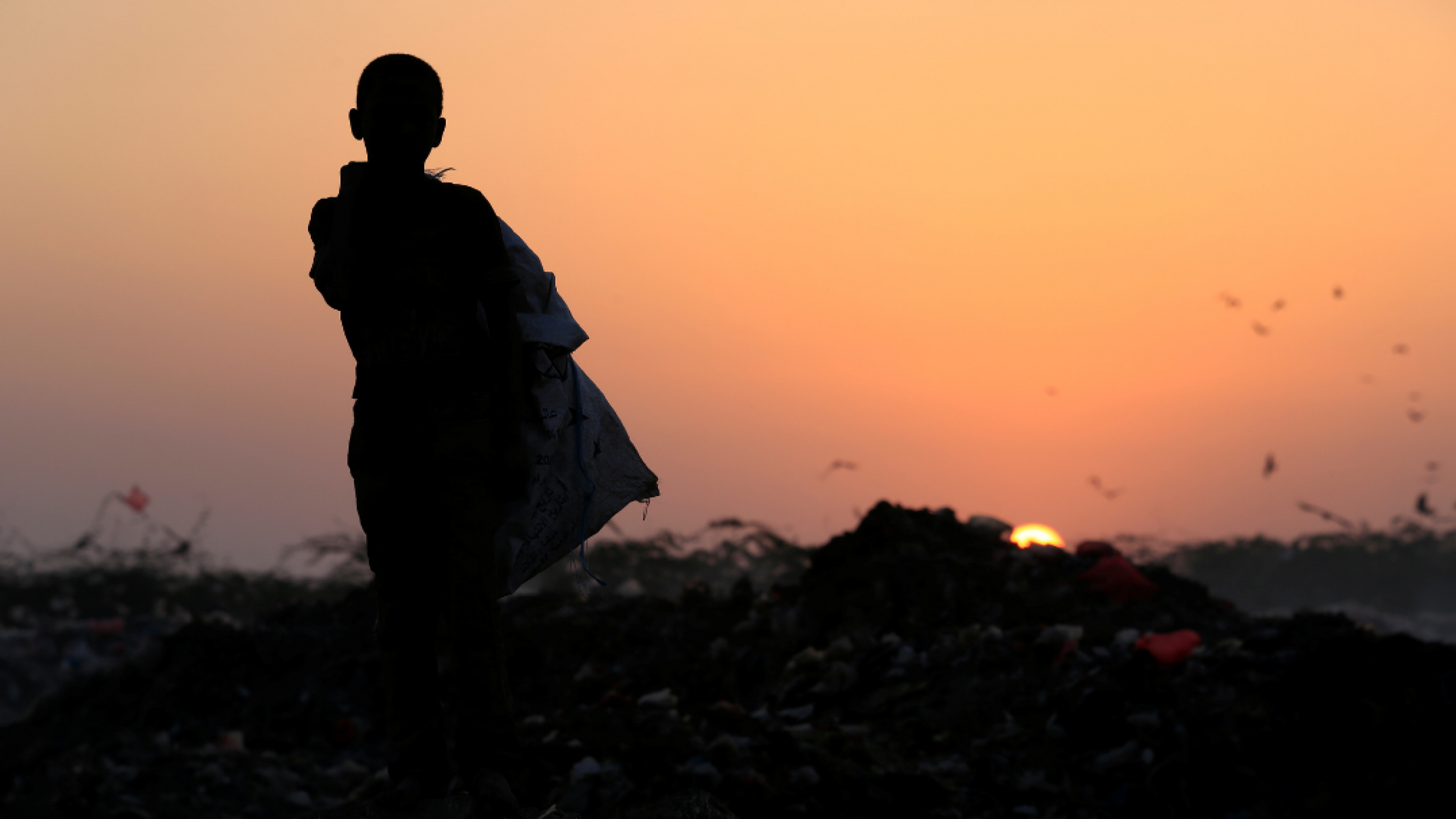 A boy stands in a garbage dump where his family collects food to eat, near the Red Sea port city of Hodeidah, Yemen on January 13, 2018.