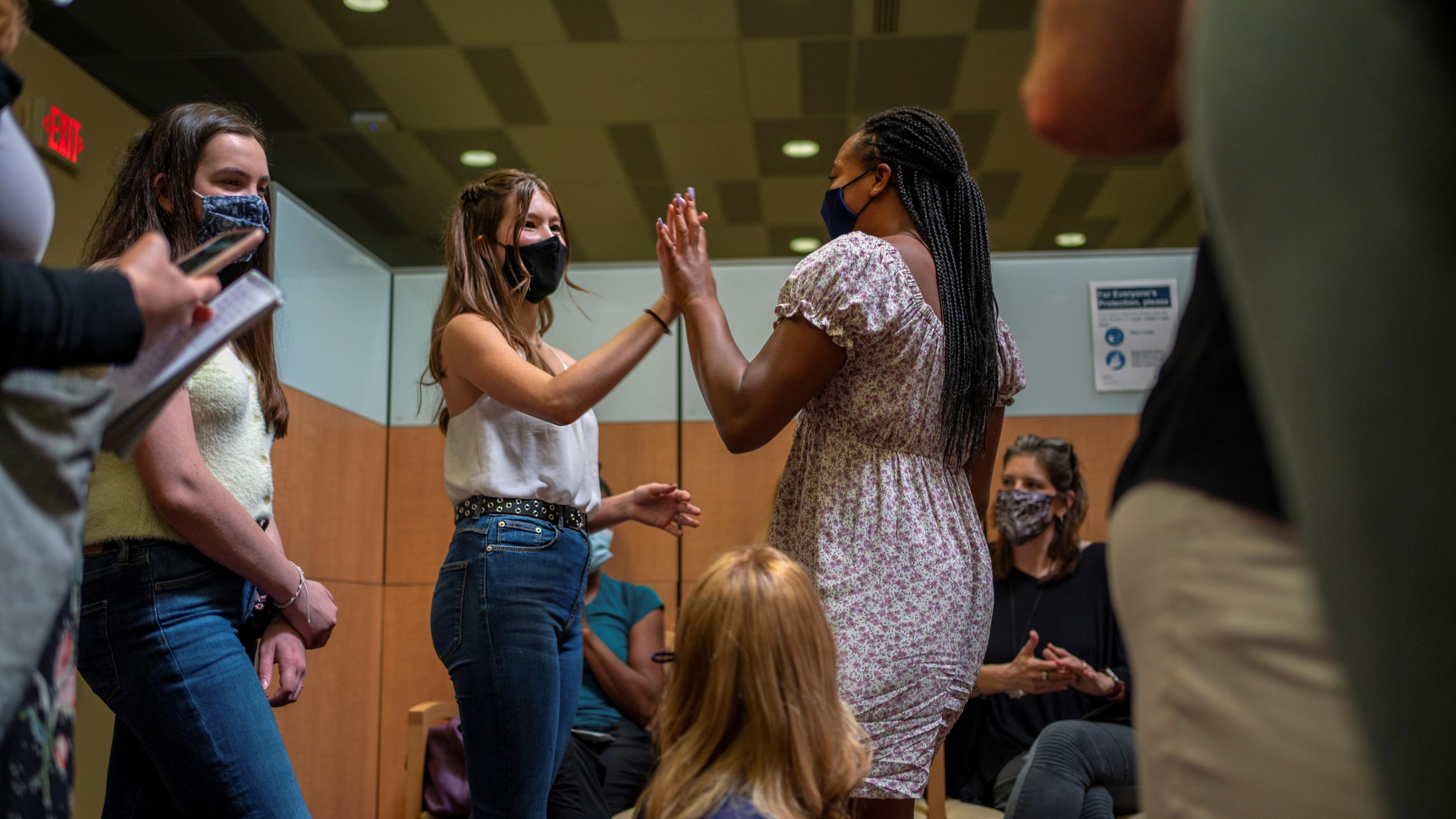 Teens  high five after Croix received her first COVID vaccine at the Ochsner Center for Primary Care and Wellness, in New Orleans, Louisiana, May 13, 2021.