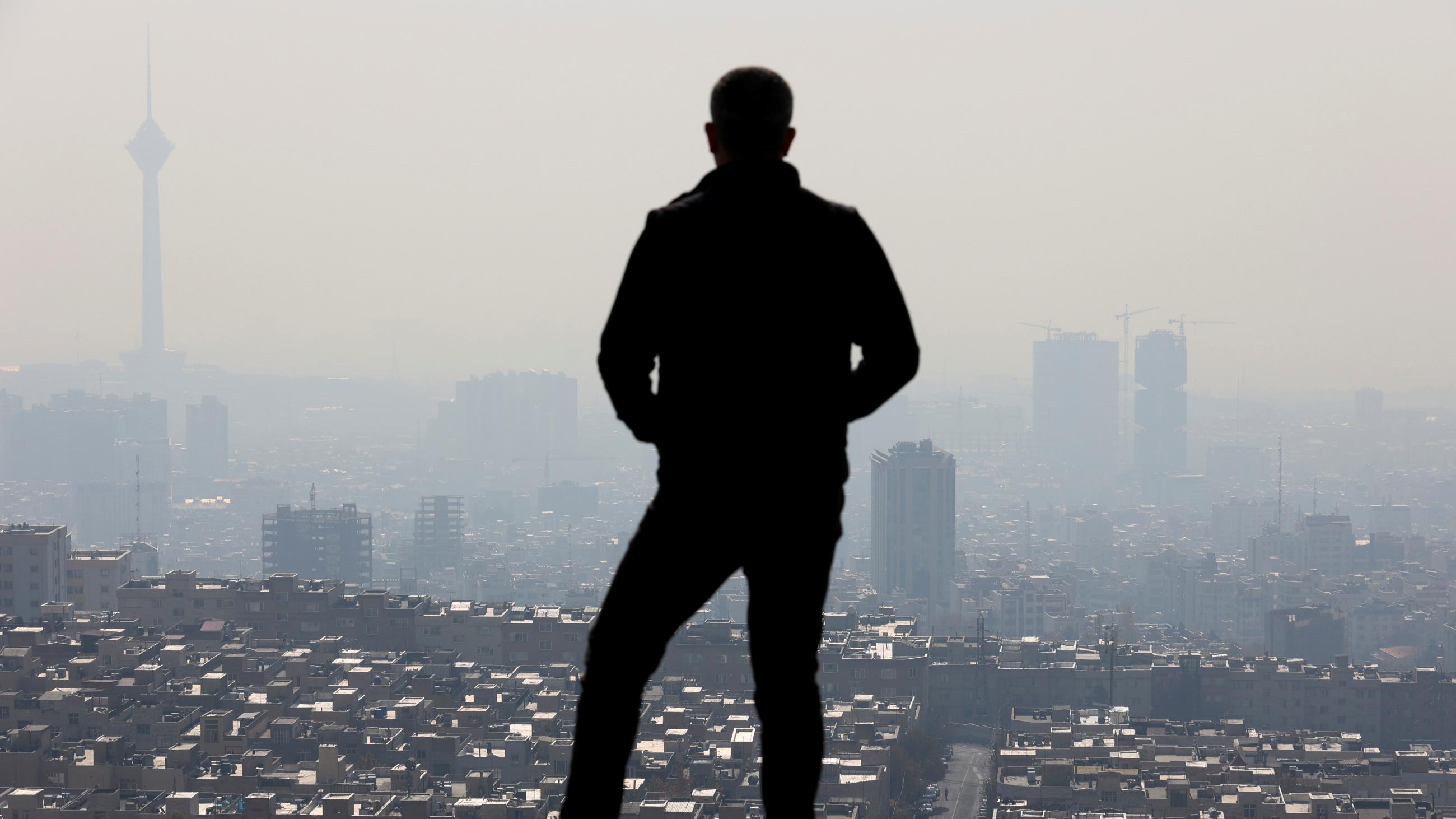 A man stands at a lookout point over Tehran following an increase in air pollution in Tehran, Iran,