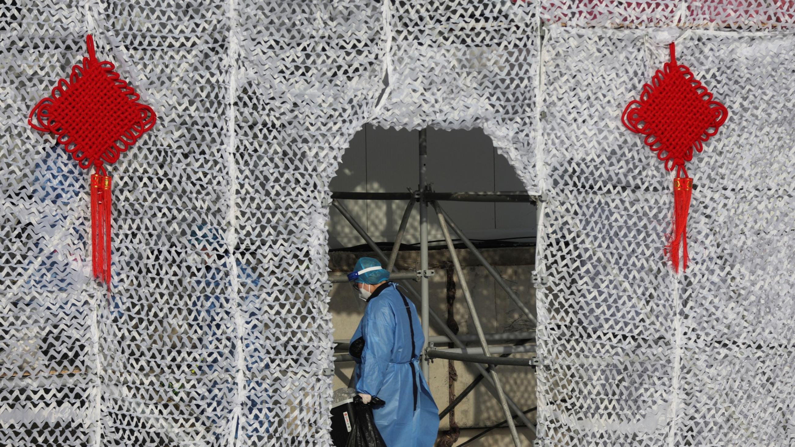 A cleaner in personal protection equipment clears garbage at a venue office decorated for the Lunar New Year at Yanqing National Alpine Ski Centre ahead of the Beijing 2022 Winter Olympics in Yanqing district of Beijing, China, January 30, 2022. 