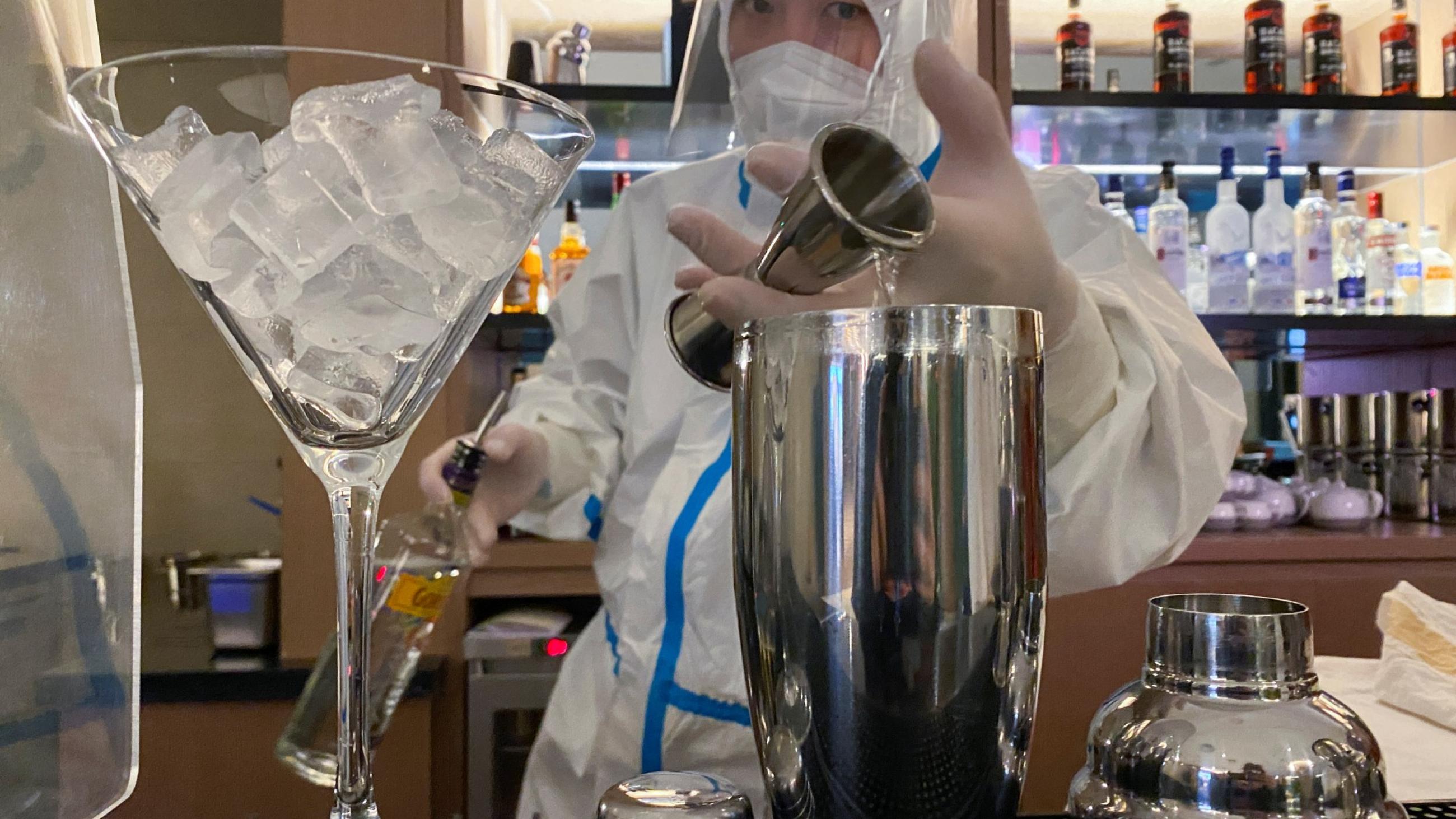 A bartender in personal protective equipment (PPE) prepares a cocktail in a hotel for journalists and officials of the Beijing 2022 Winter Olympics, in Zhangjiakou, China, February 3, 2022.