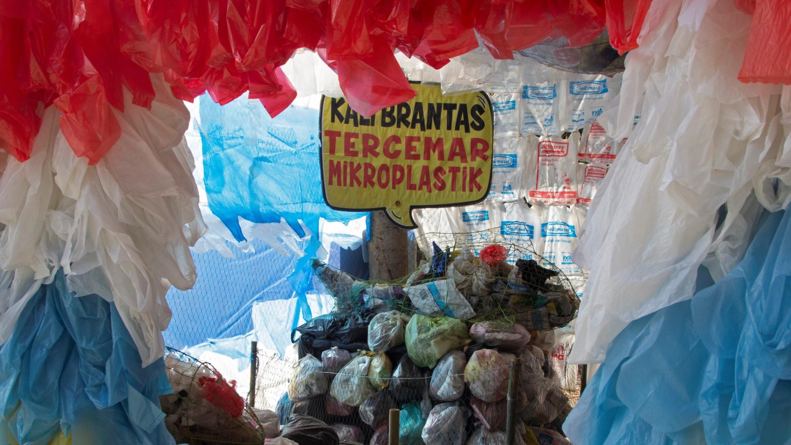 a placard that reads "Brantas river polluted with microplastics," is seen among plastic bags displayed at the plastic museum constructed by Indonesia's environmental activist group Ecological Observation and Wetlands Conservation