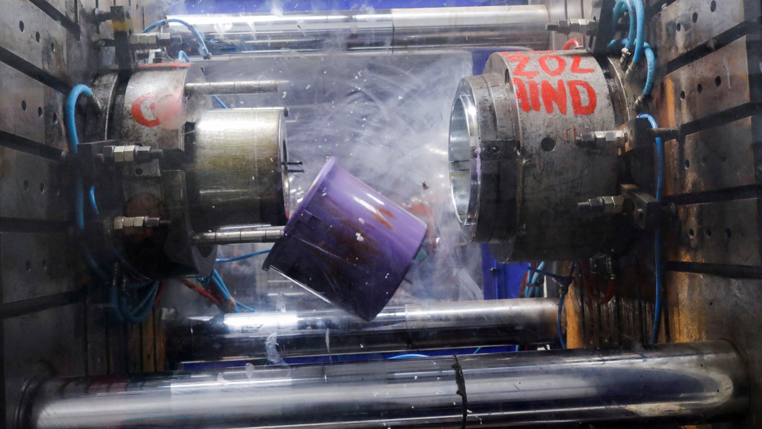 a purple plastic bucket tumbles as its being cooled at a factory line in Dakar, Senegal