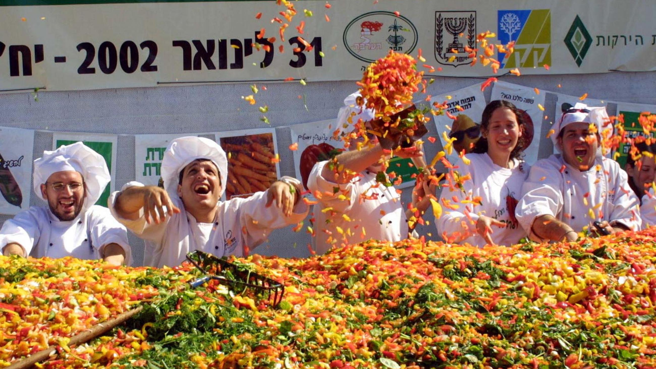 Israeli chefs celebrate after preparing a giant salad setting a new world record in the southern Israeli town of Araba January 31, 2002.