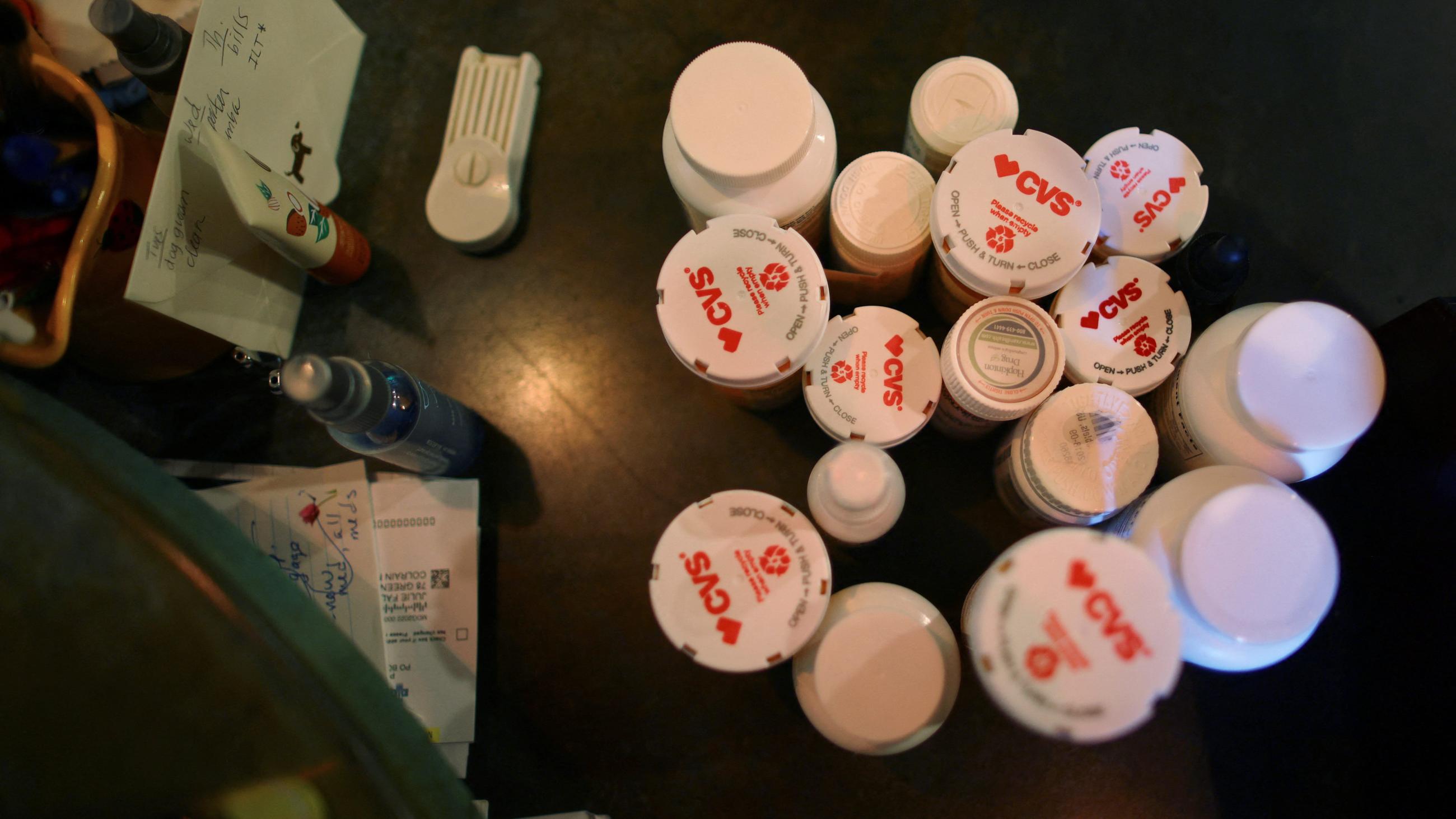 Julie Fallon, who describes her long COVID symptoms as “extreme cognitive challenges,” has her medications gathered on her kitchen counter at her home in Colrain, Massachusetts, on June 15, 2022.