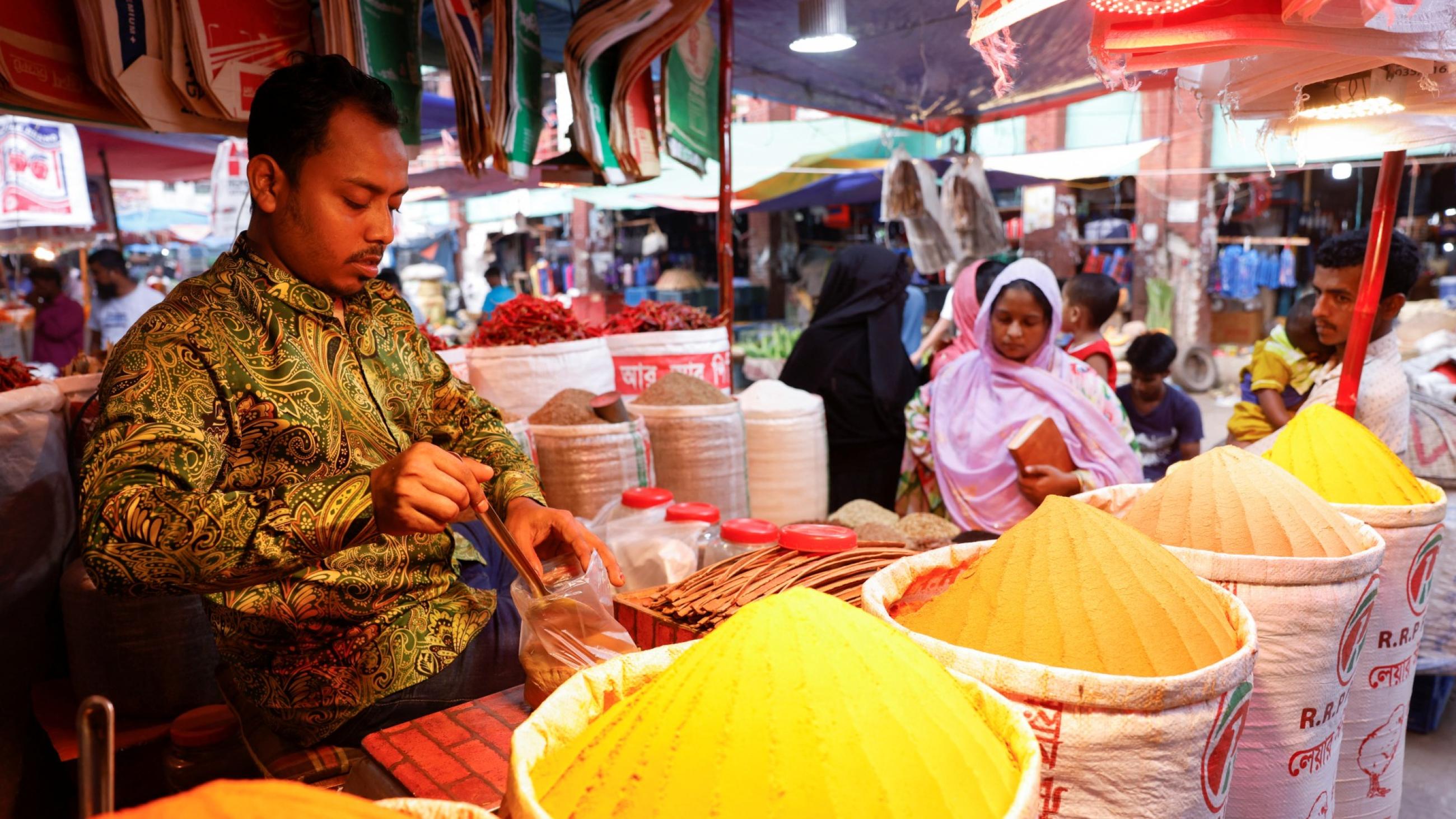 A shopkeeper sells powdered spices at Kawran Bazar, in Dhaka, Bangladesh, on May 22, 2022.